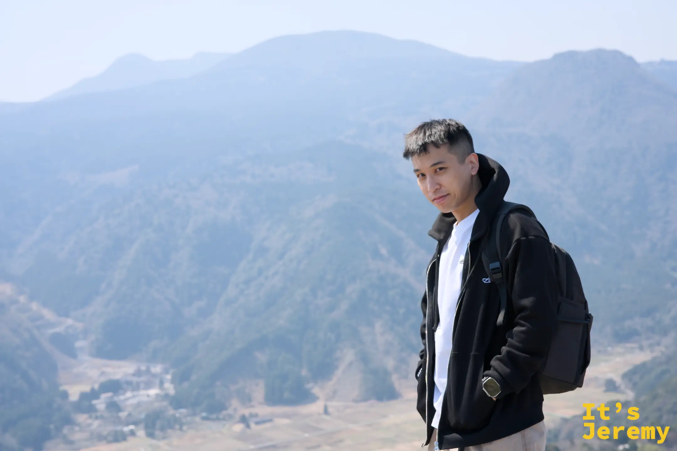 Jeremy 站在山頂，背後是伊豆山脈的藍灰色層疊輪廓