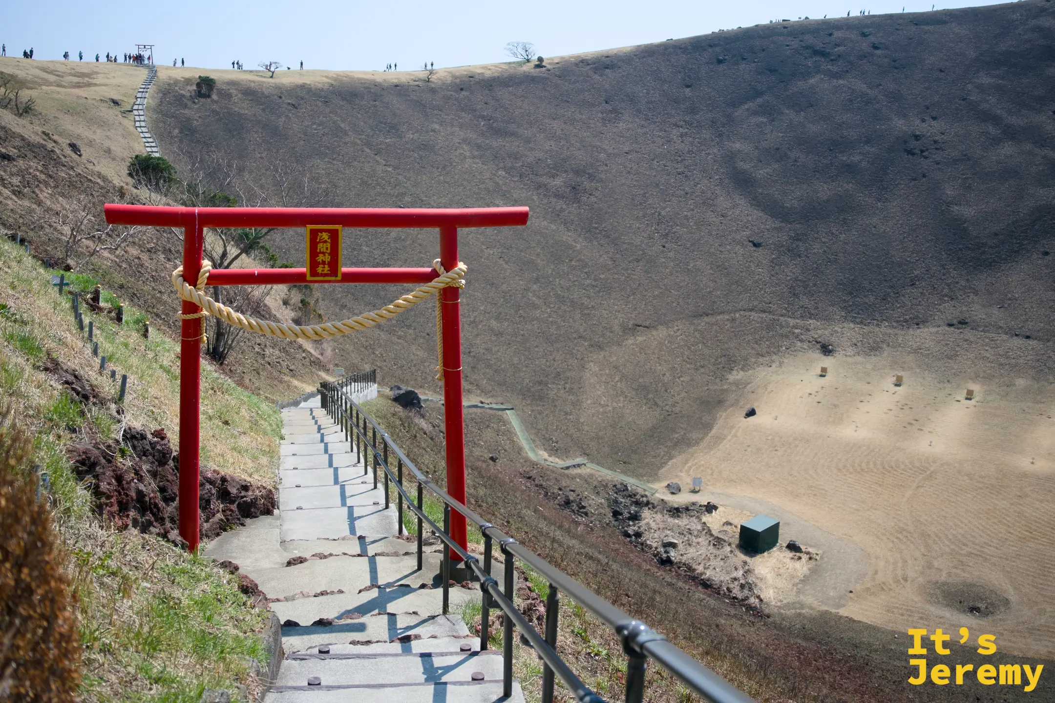 淺間神社朱紅鳥居架在通往火山口底部的石階入口，右側可見碗形火山口全景