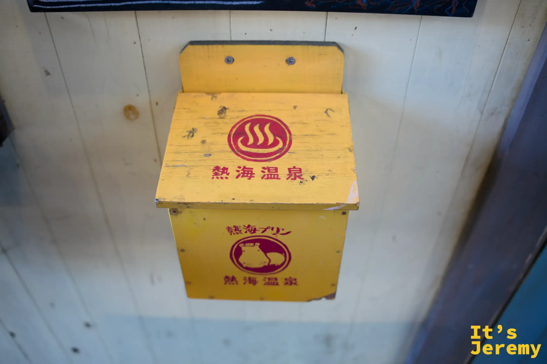 熱海プリン店外橘黃色招牌信箱，印有熱海温泉字樣與河馬圖騰，質感復古