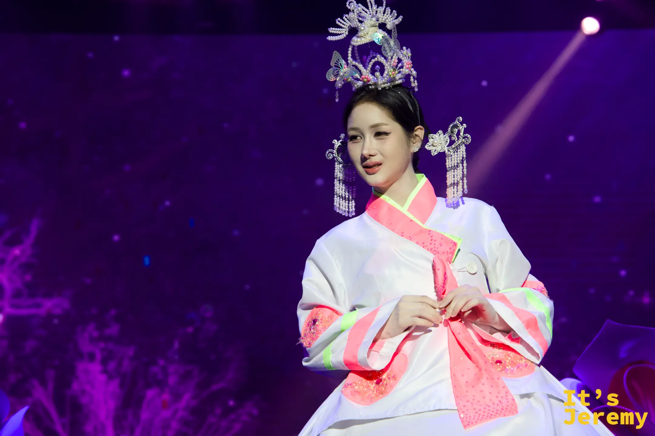 金東尼人妖秀舞台上，舞者身穿改良式韓服，頭戴華麗的銀色流蘇髮冠與髮飾，在紫色燈光下優雅走秀。