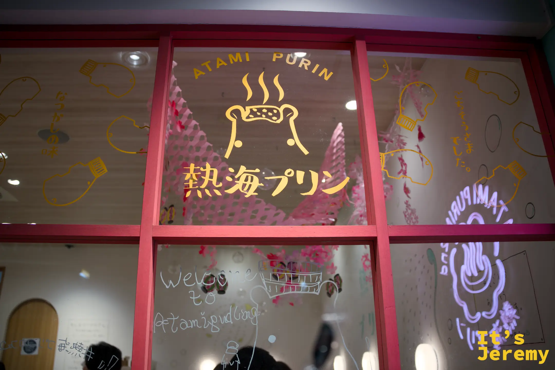 熱海プリンカフェ 2nd 玻璃窗貼有金色 ATAMI PURIN 字樣，店內裝潢透過玻璃清晰可見