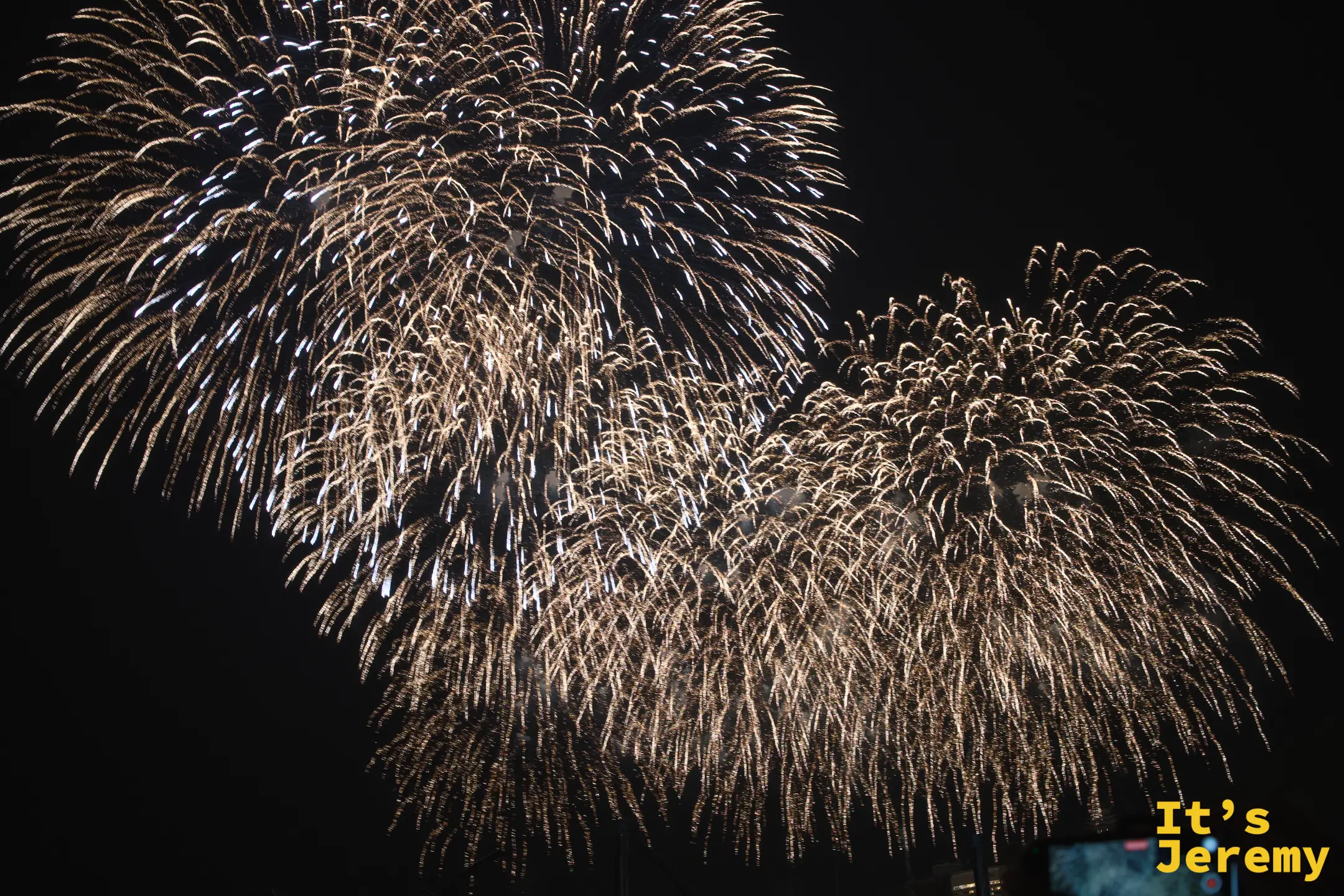金白色煙火多顆同時綻放的近距離特寫，夜空被照得一片金亮