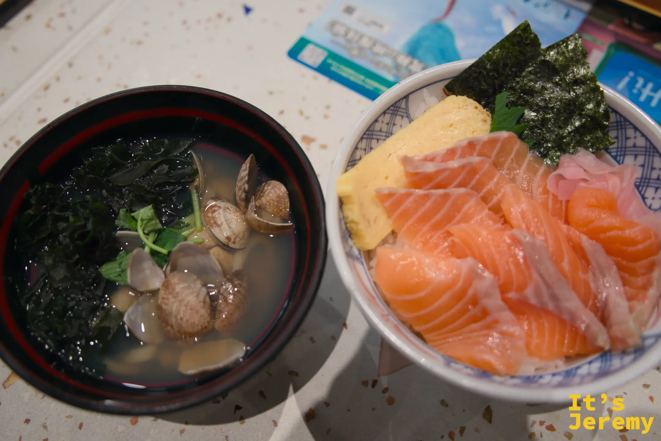 蛤蜊海帶芽烏龍麵與鮭魚丼並排上桌，湯頭清澈，蛤蜊殼沉在深色碗底