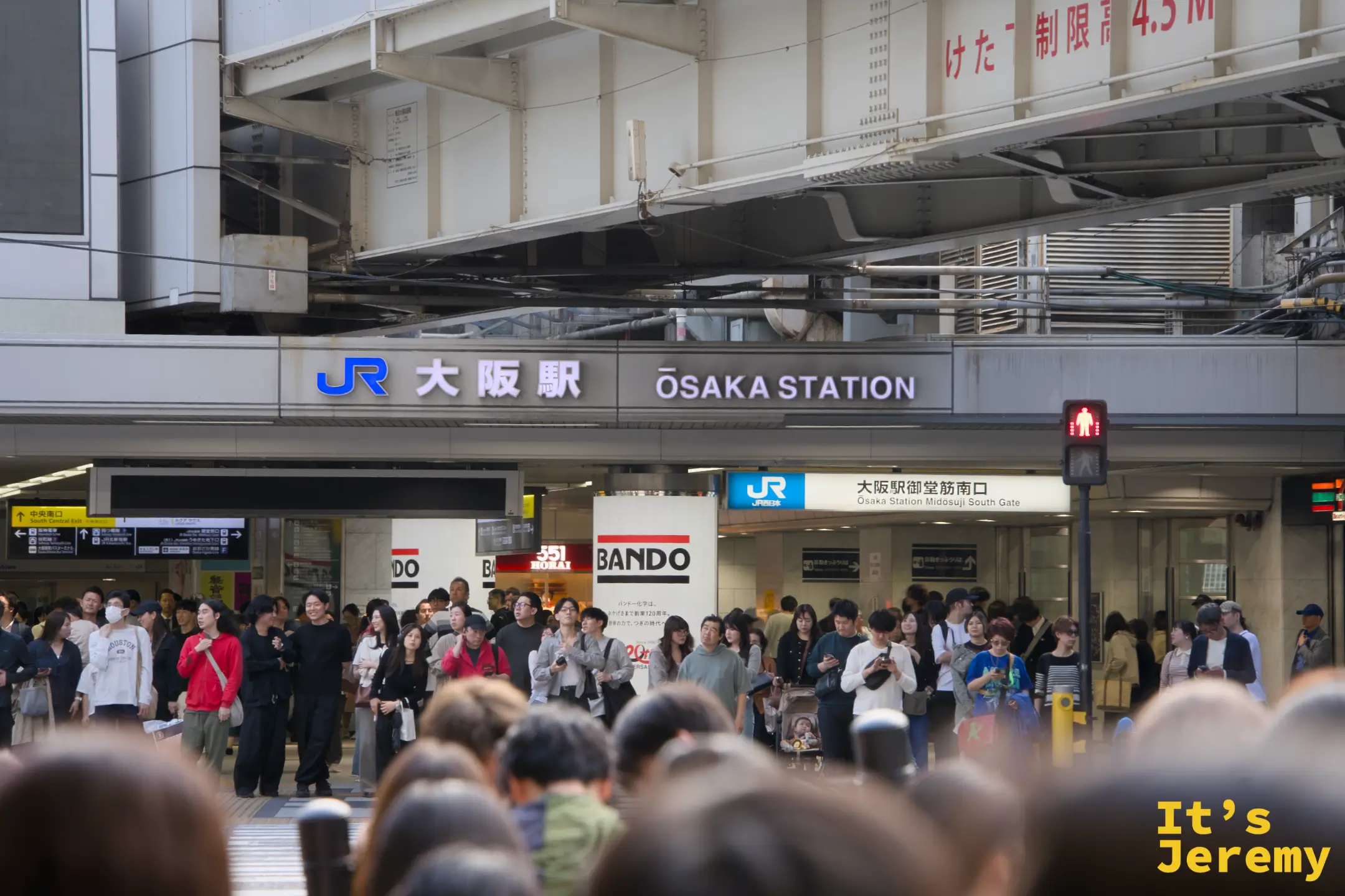 JR 大阪駅御堂筋南口站前，等紅燈的人群背後是整排站牌，大阪駅四個字直接掛在正面