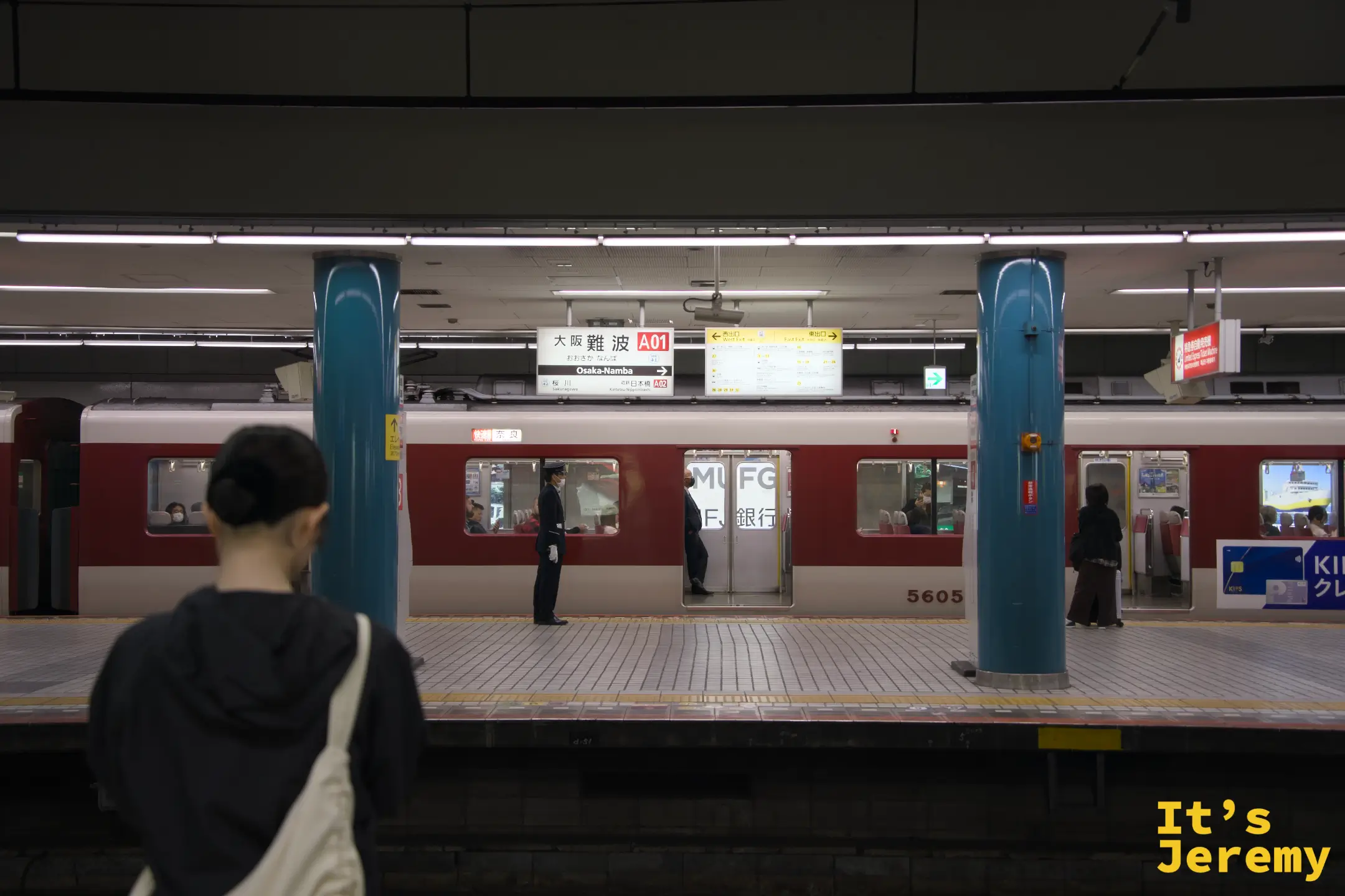 大阪難波站近鐵月台，A01 站名標誌清晰可見，等車的上班族與遊客並排