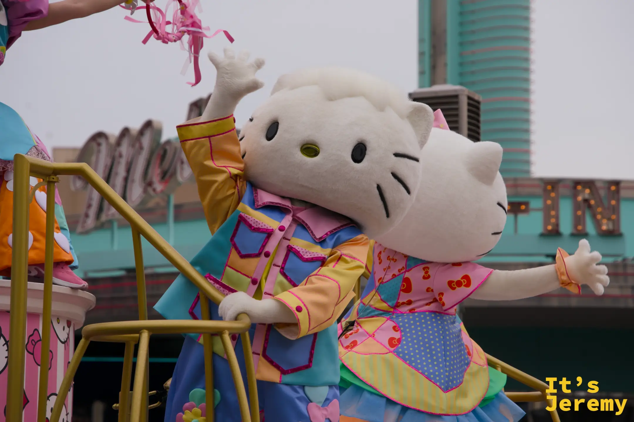 Hello Kitty 與 Dear Daniel 緊靠在一起向觀眾招手，兩人的服裝是 25 週年限定款花衫設計