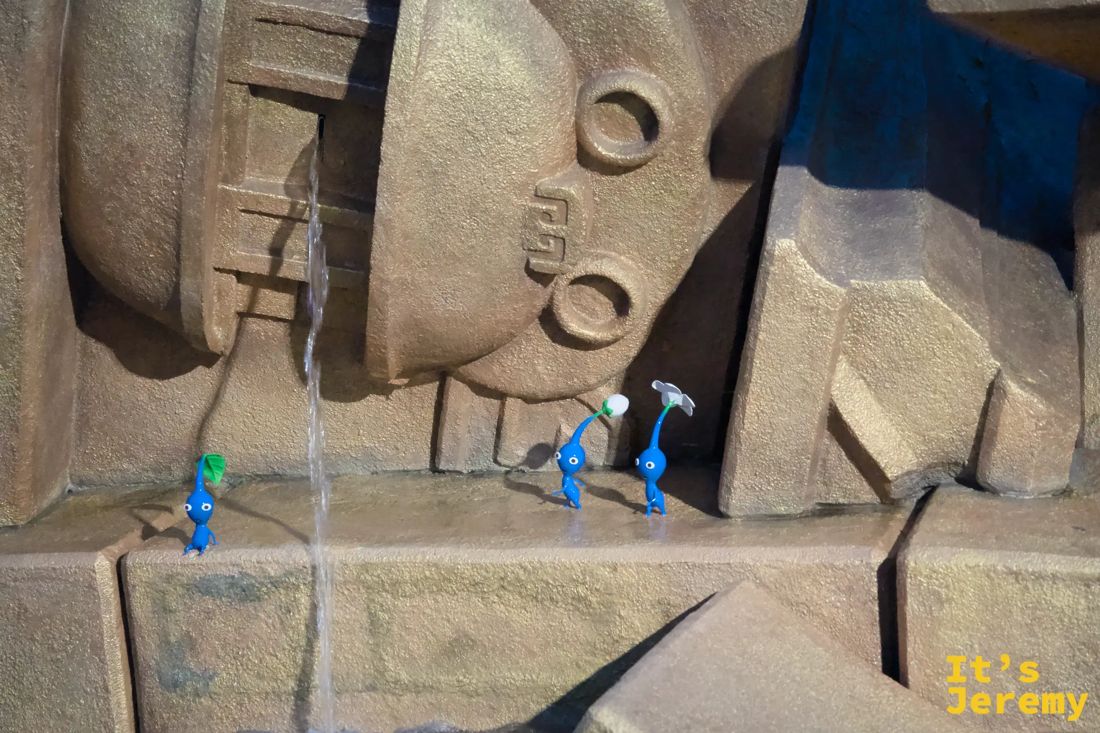 DKC 區域的石牆水流旁，三隻藍色 Pikmin 出現在縫隙中，充滿驚喜感的彩蛋細節