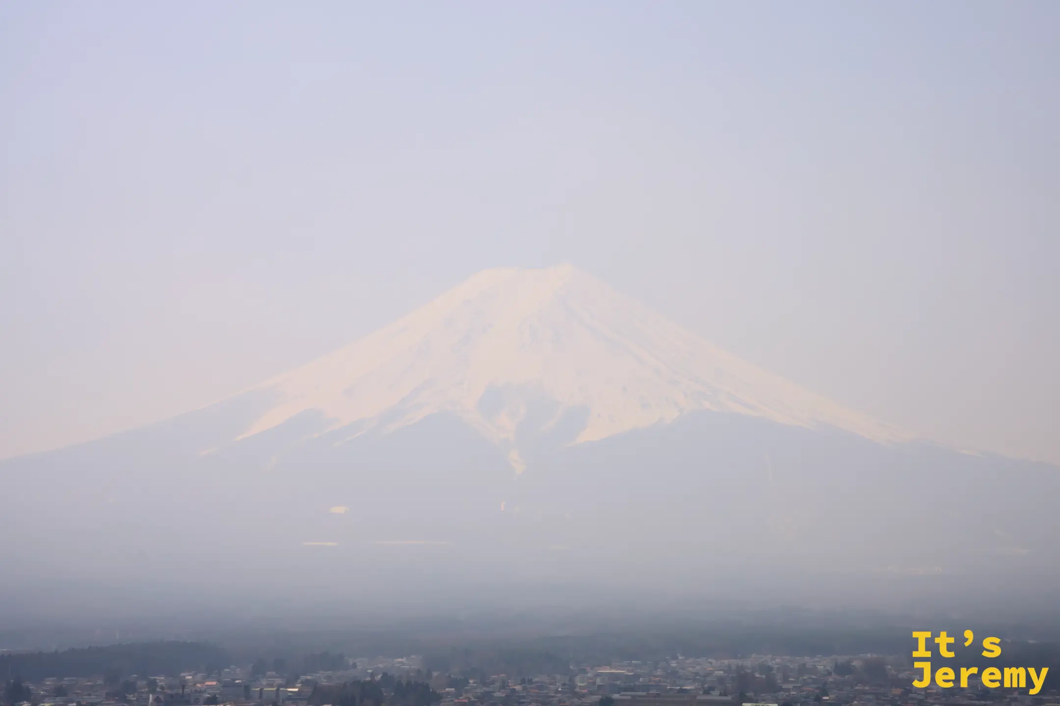 從最高觀景台望出去，沙塵讓富士山幾乎與天空溶成同一片灰白，山下市區隱約可見