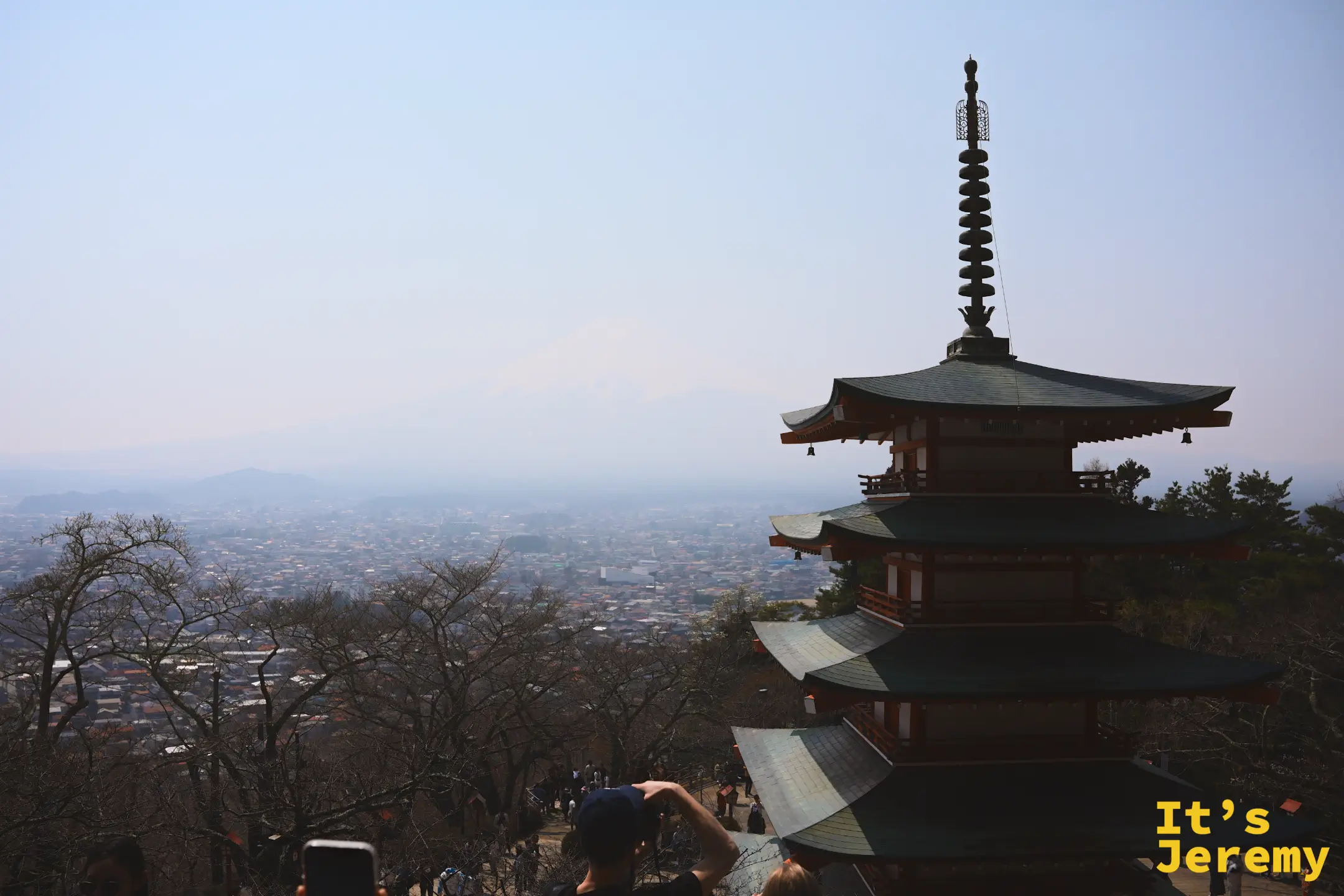 忠霊塔五層紅塔俯看下吉田市區，富士山的輪廓在霾氣中若隱若現