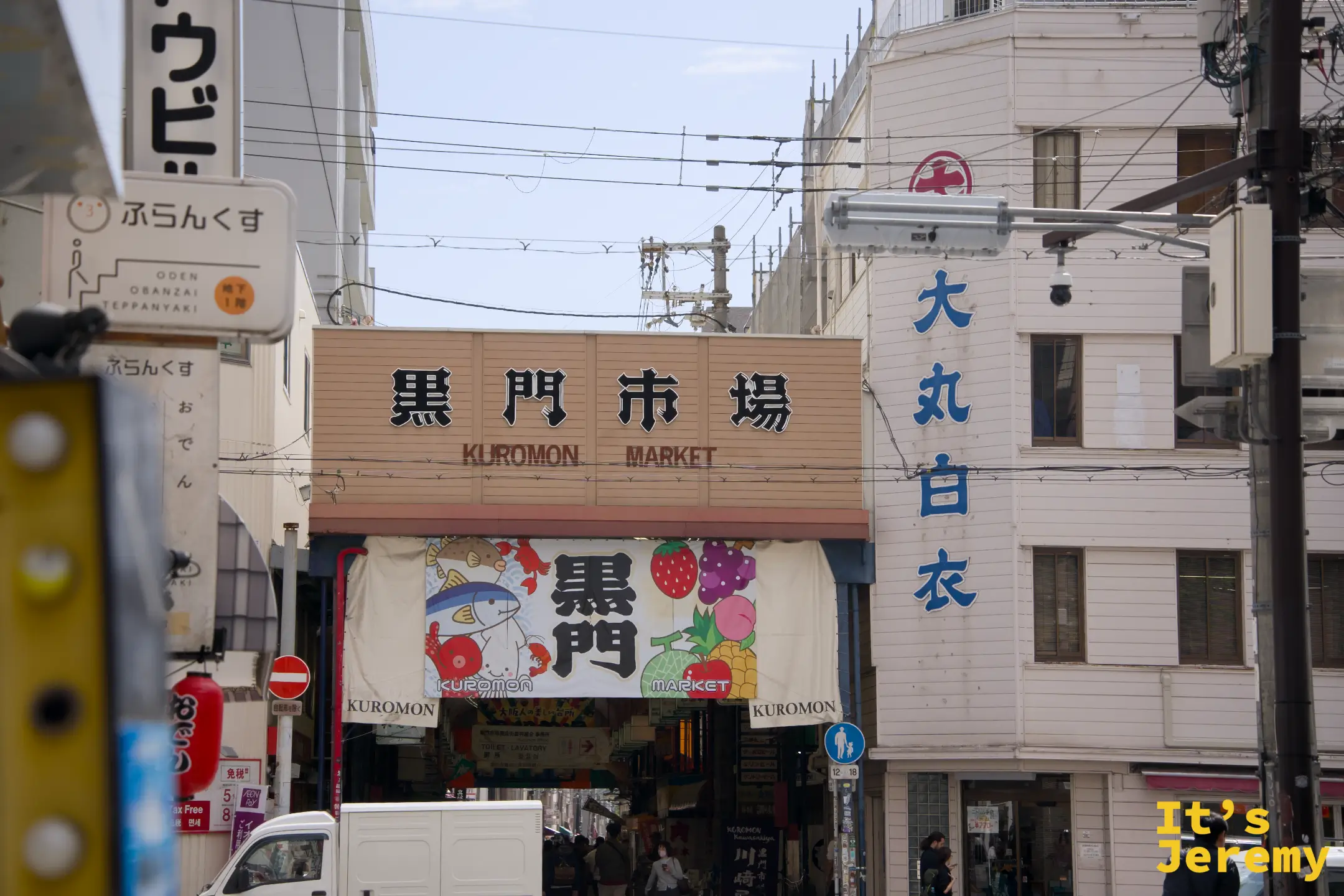 黒門市場入口招牌特寫，遠遠就能看見「黒門市場 KUROMON MARKET」大字