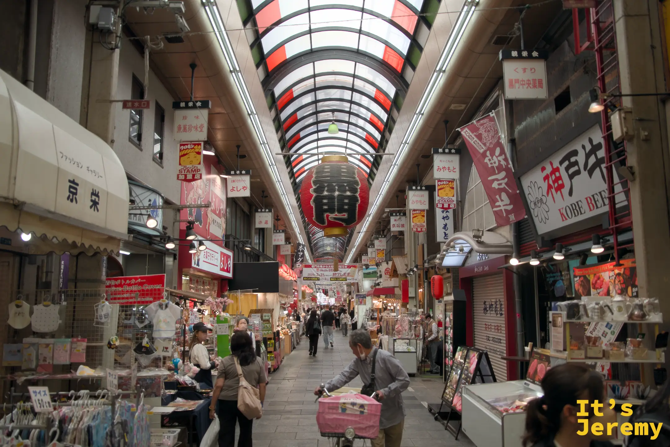 市場拱廊全景，可以看到神戶牛旗幟與各家攤位並排