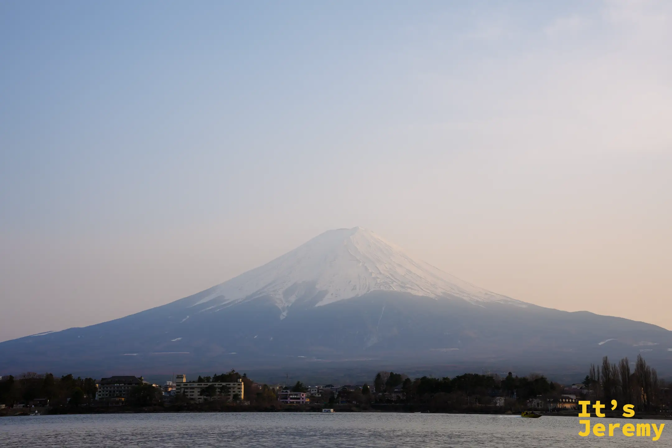 入夜前的富士山，天邊泛起一層暖橘餘光，積雪山脊在光線裡格外清晰