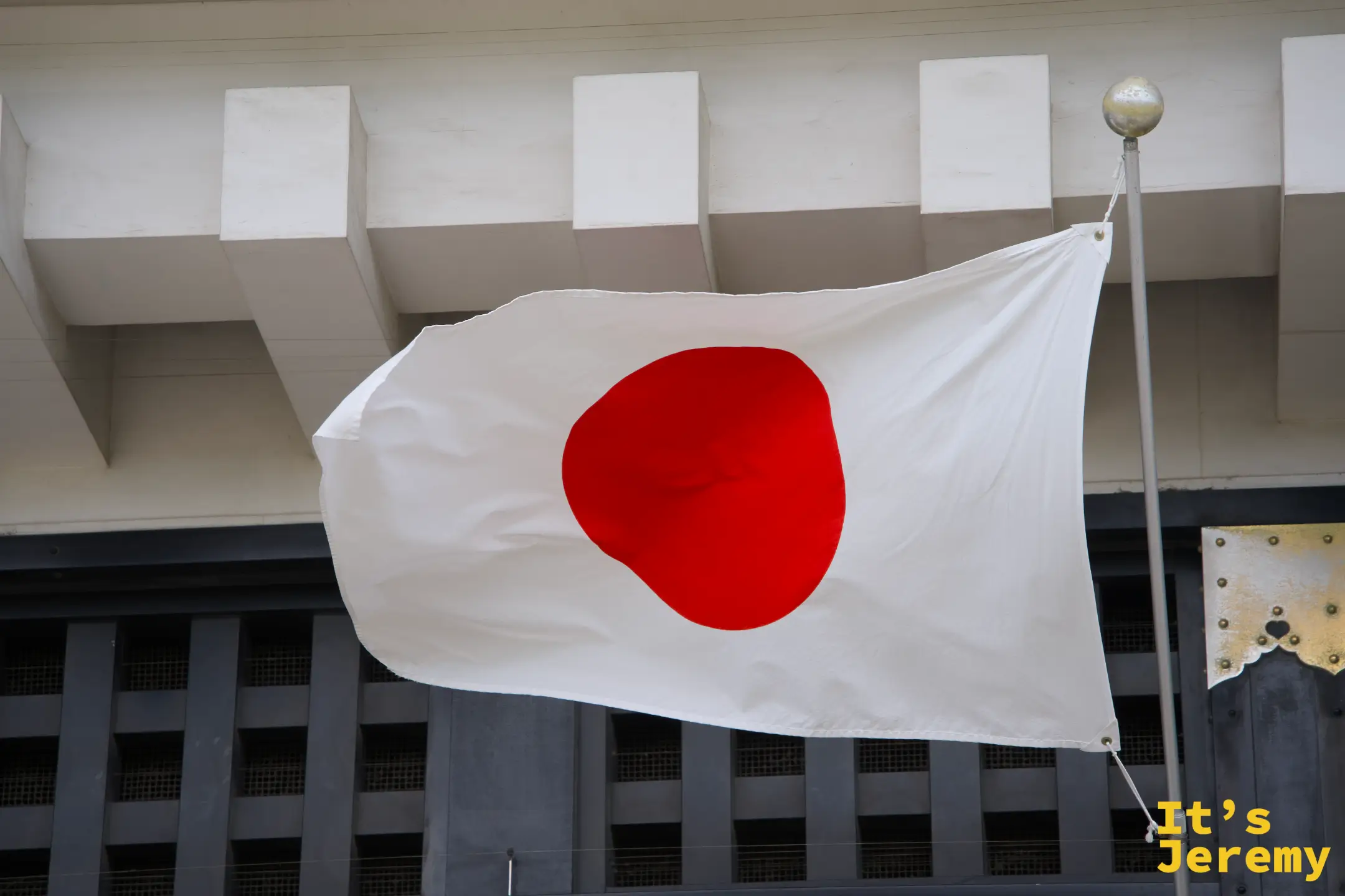 城牆石壁前的日本國旗，旗面在天空中展開