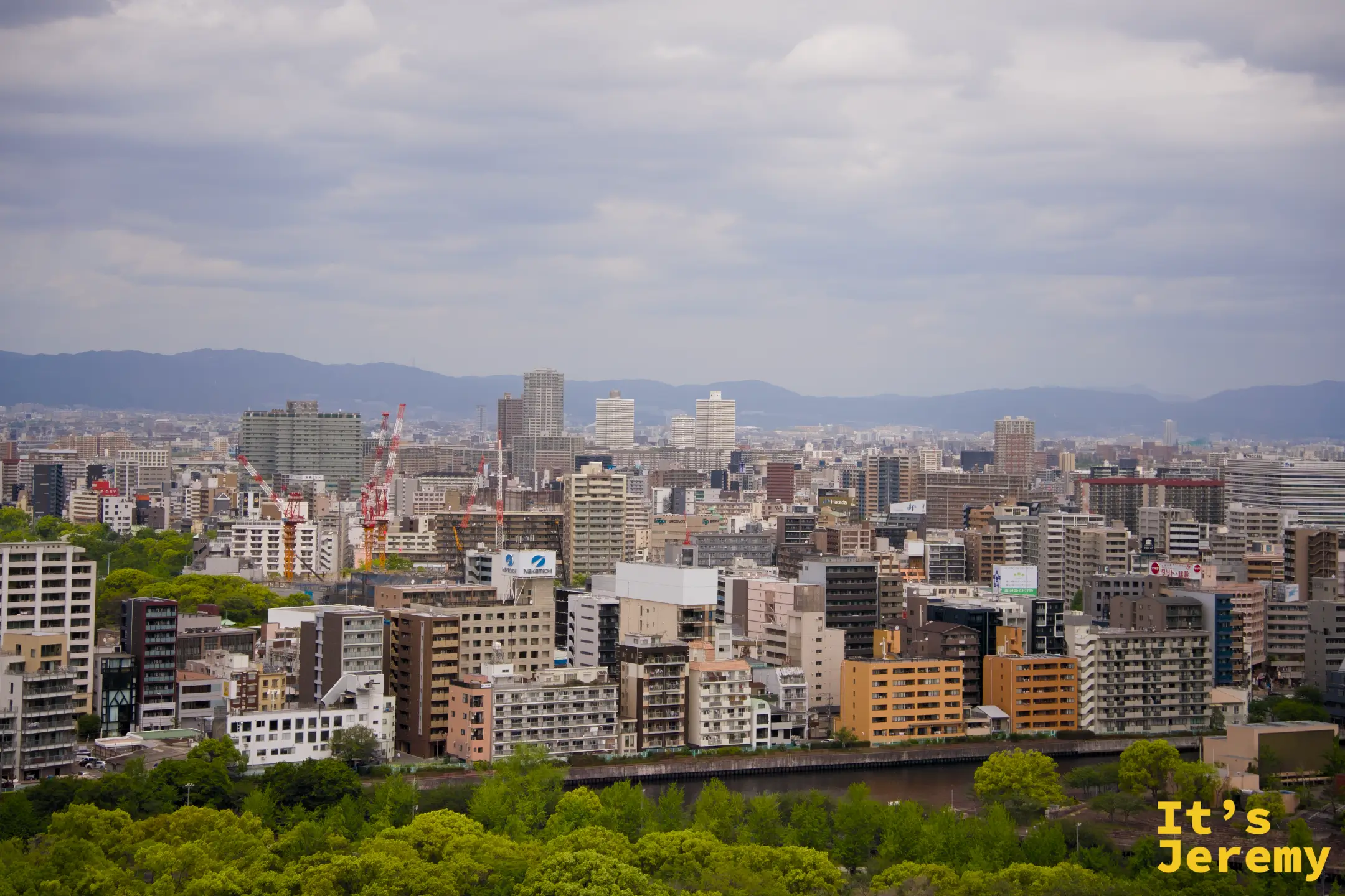 從頂層展望台俯瞰大阪市區全景，建築群延伸至遠方山脈