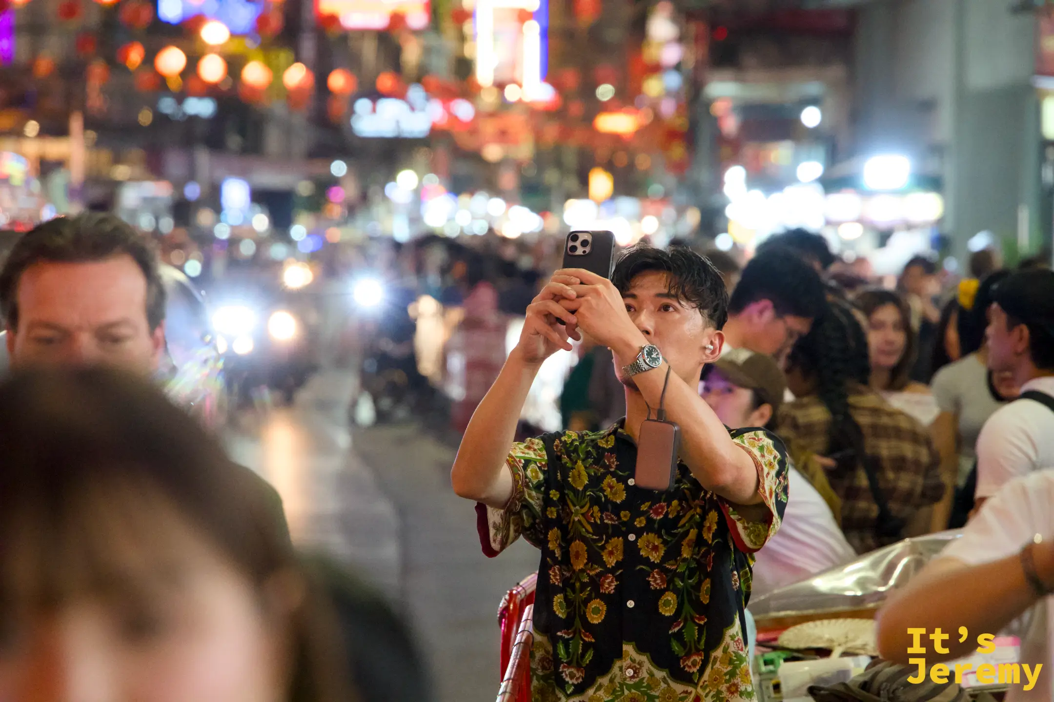 另一位路人停在街邊舉起手機拍攝唐人街街景
