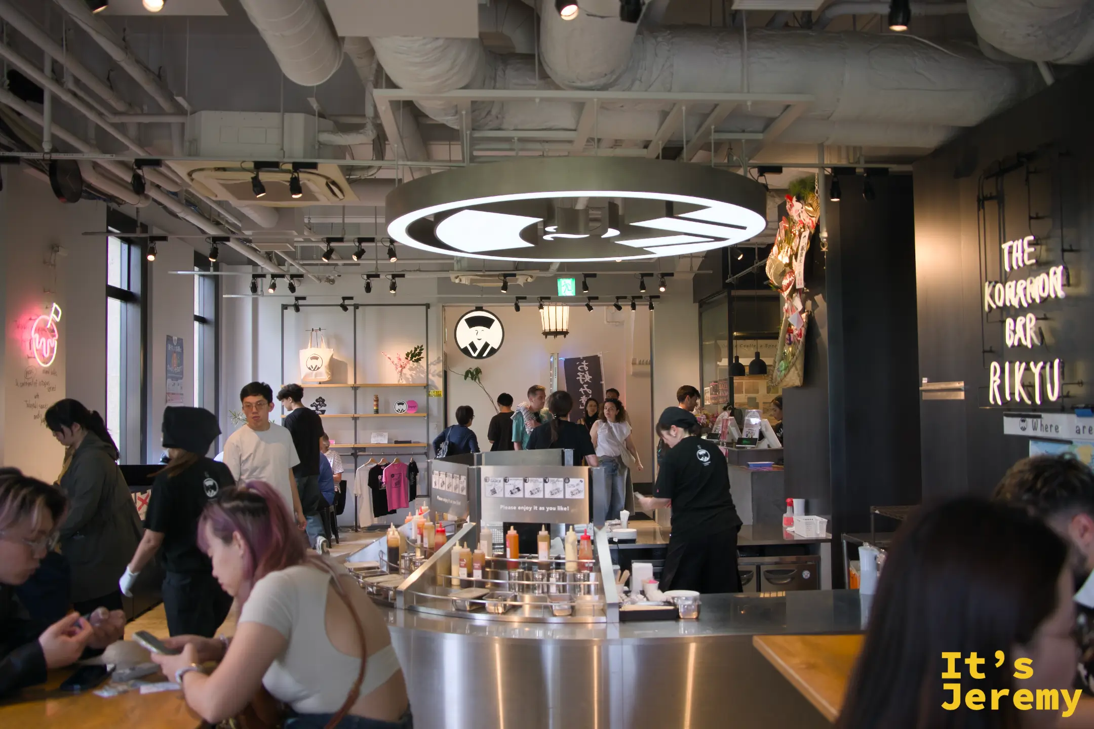 THE KONAMON BAR RIKYU 店內環境，工業風設計搭配霓虹店名招牌，座無虛席