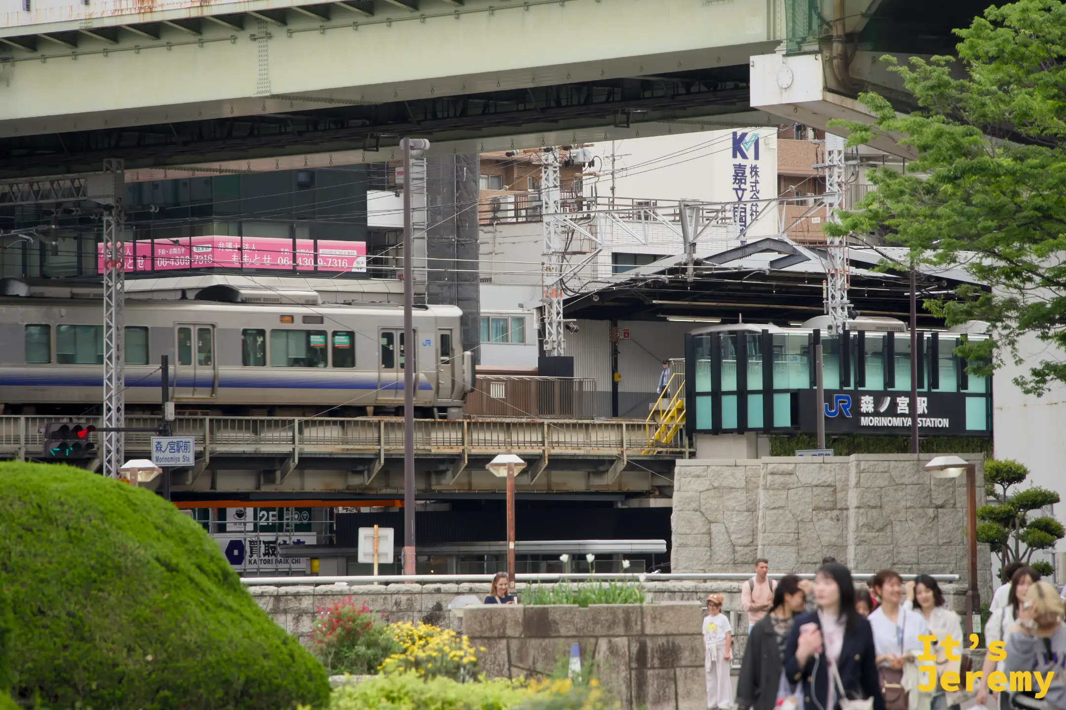 JR 森ノ宮駅站牌近拍，電車停靠月台，行人在前方廣場穿梭