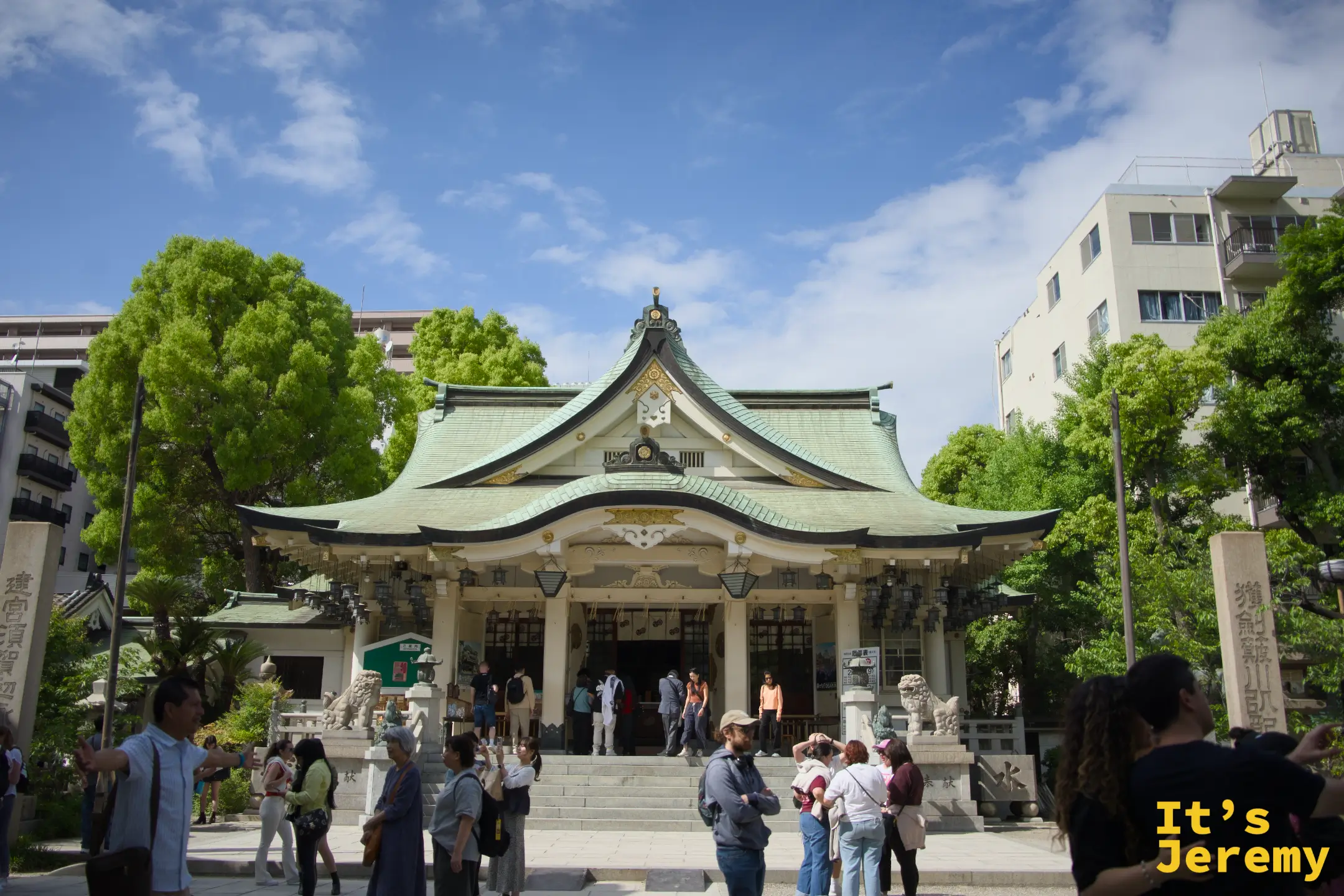 難波八阪神社拜殿正面全景，藍天白牆翠綠屋頂