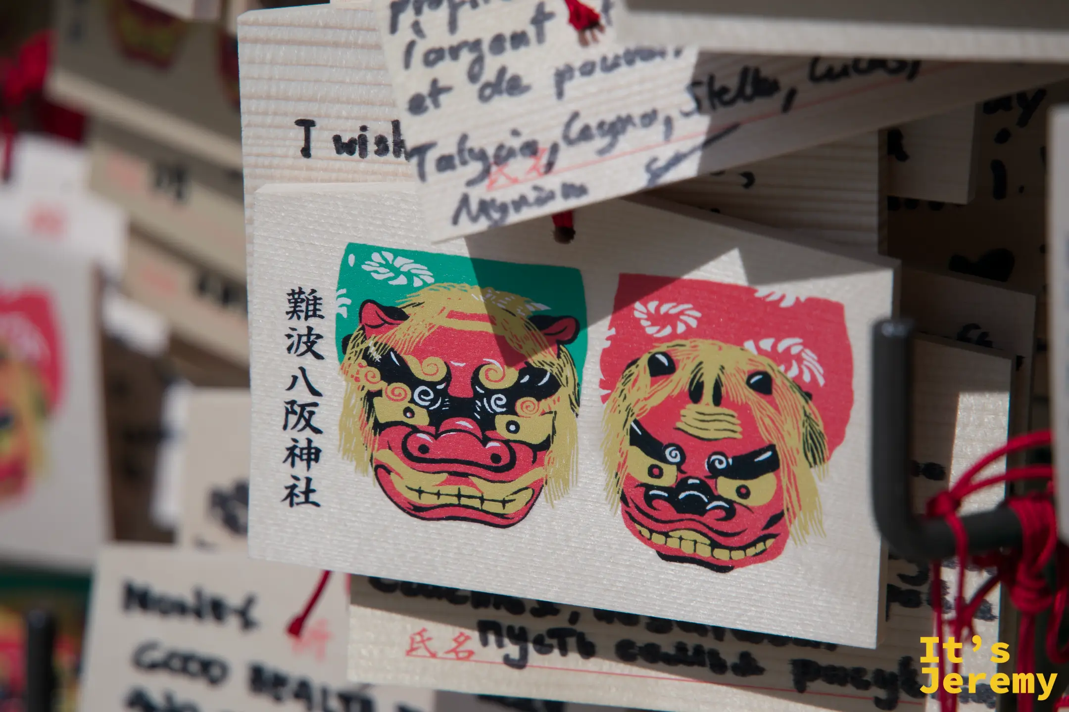 繪馬特寫，難波八阪神社獅子圖案清晰可見，旁邊有外文許願文字