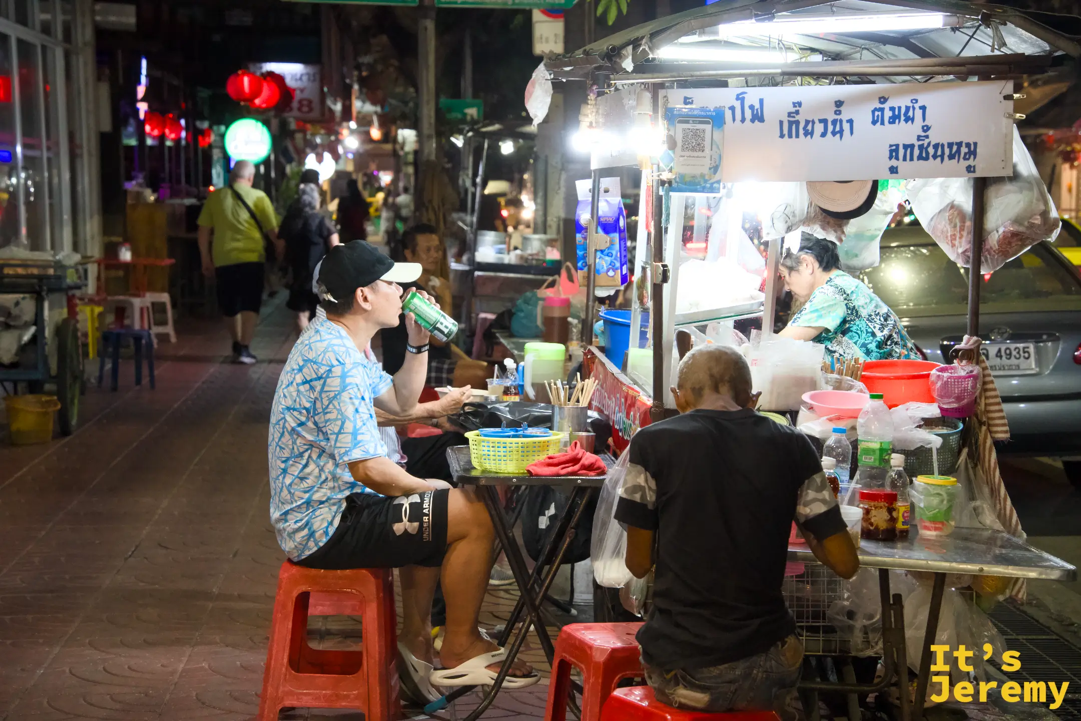 唐人街街邊小販以及坐在攤位前用餐的客人