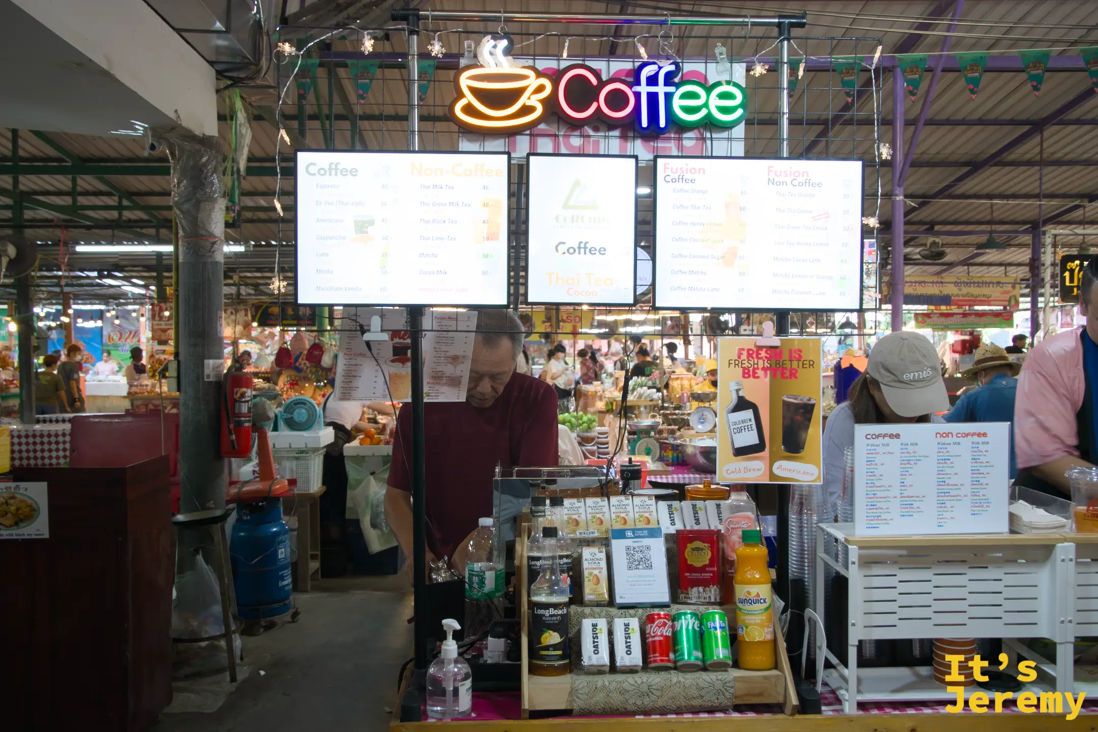 CoffCups 飲料攤的霓虹「Coffee」招牌與菜單板，市場裡最容易認的補水據點