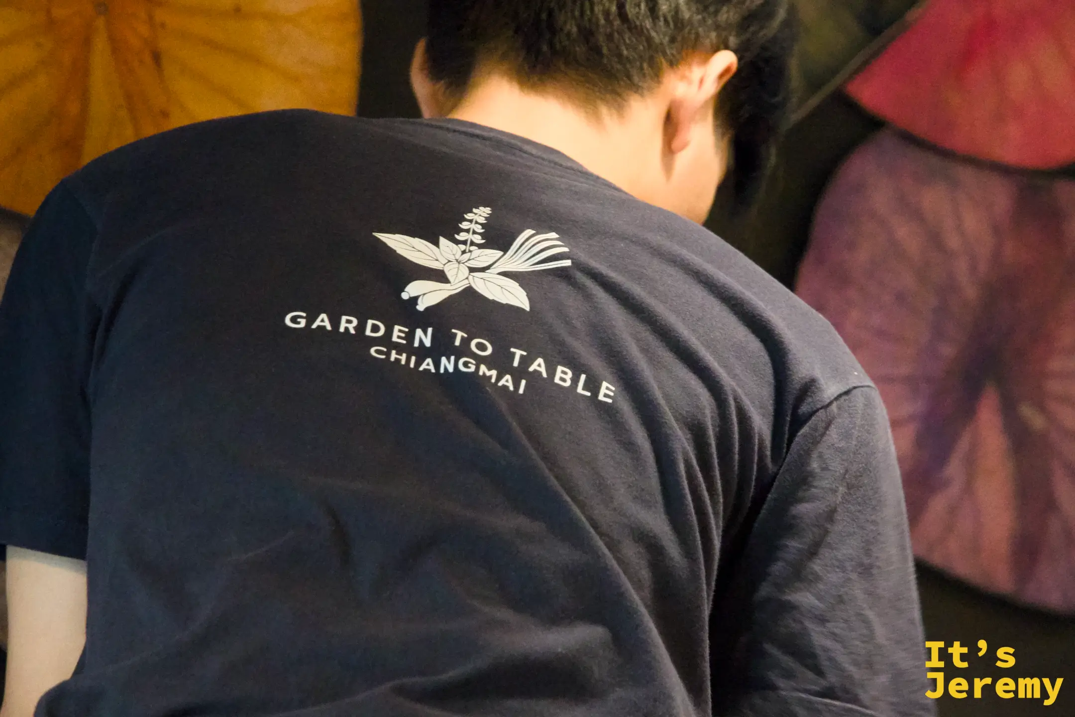 工作人員身著印有 Garden to Table Chiangmai 標誌的深藍制服