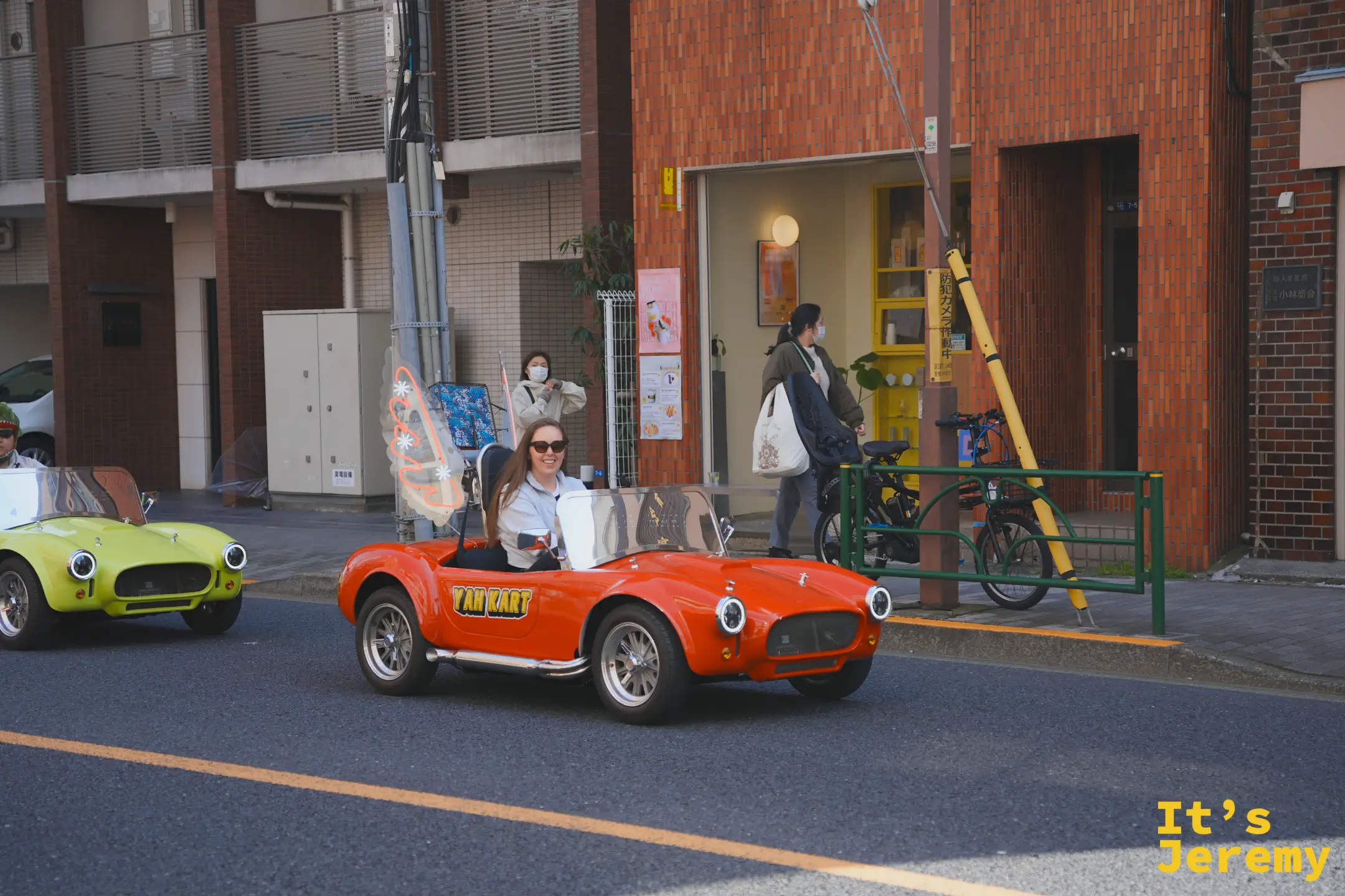 一名女性旅客駕駛紅色 YAH KART 復古小跑車型卡丁車行駛在淺草街道