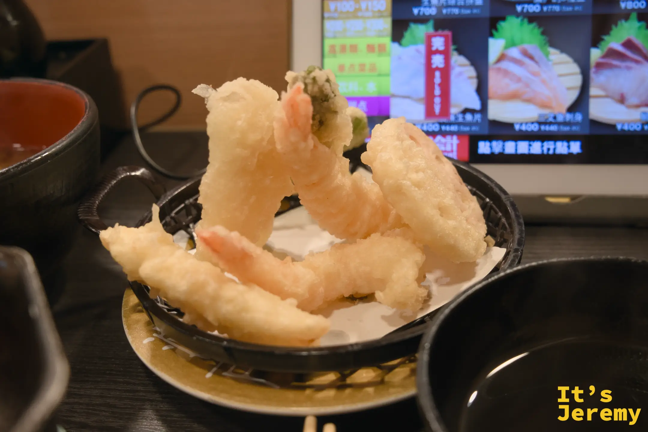 黑色小缽盛著多隻炸蝦天婦羅，裹著酥脆金黃麵衣，蝦尾粉紅色突出