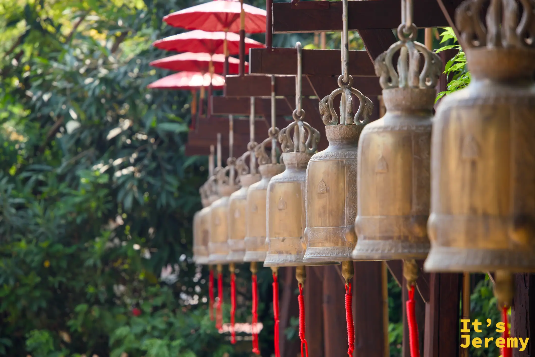 盼道寺青銅寺鐘排列，紅繩垂下，後方隱約可見紅色傘燈