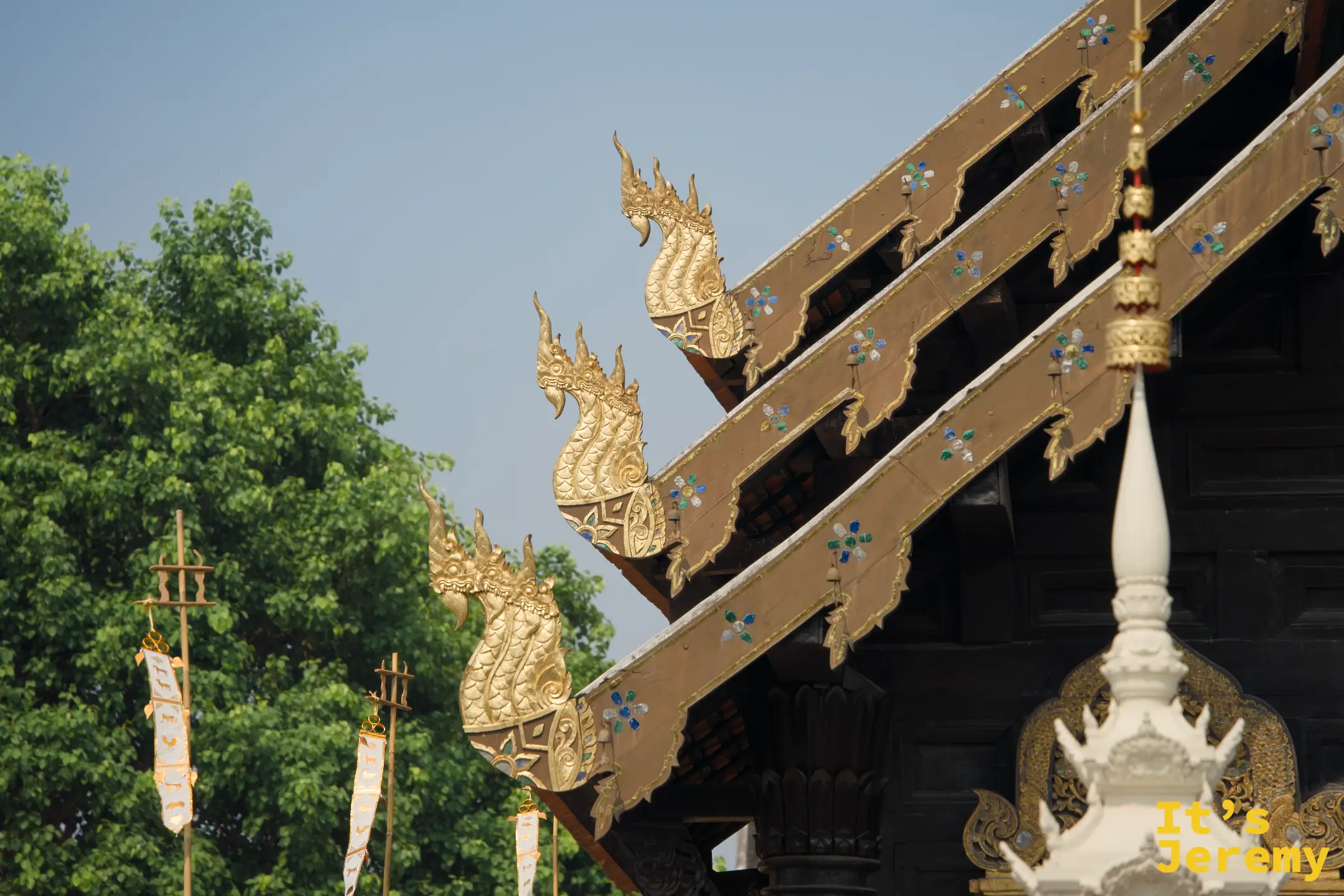 盼道寺多層屋簷末端的金色 Hamsa 神鳥裝飾，白色旗幡飄揚