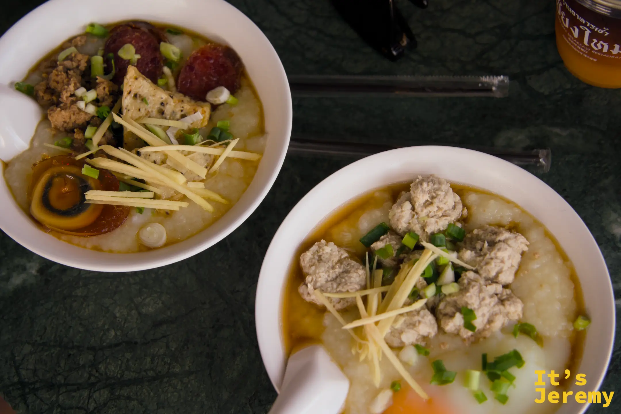 從上方俯拍兩碗粥，左邊為皮蛋粥（可見皮蛋、薑絲），右邊為另一碗粥（肉丸、蛋黃）