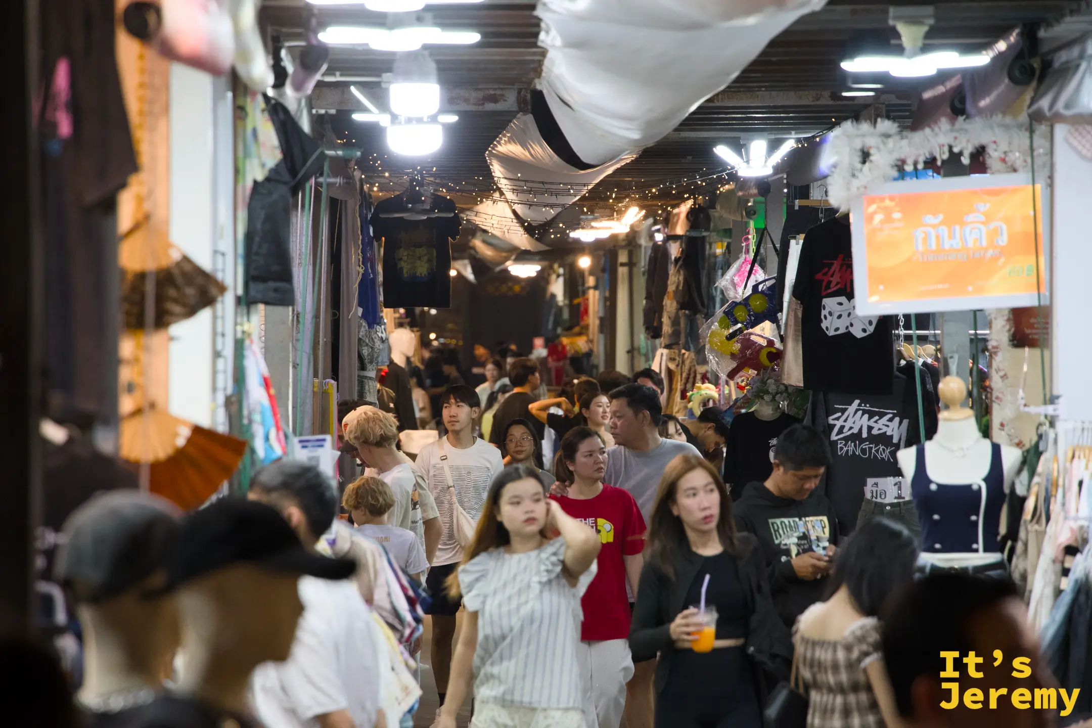 夜市中央走道的人潮與兩側鐵皮屋頂攤位