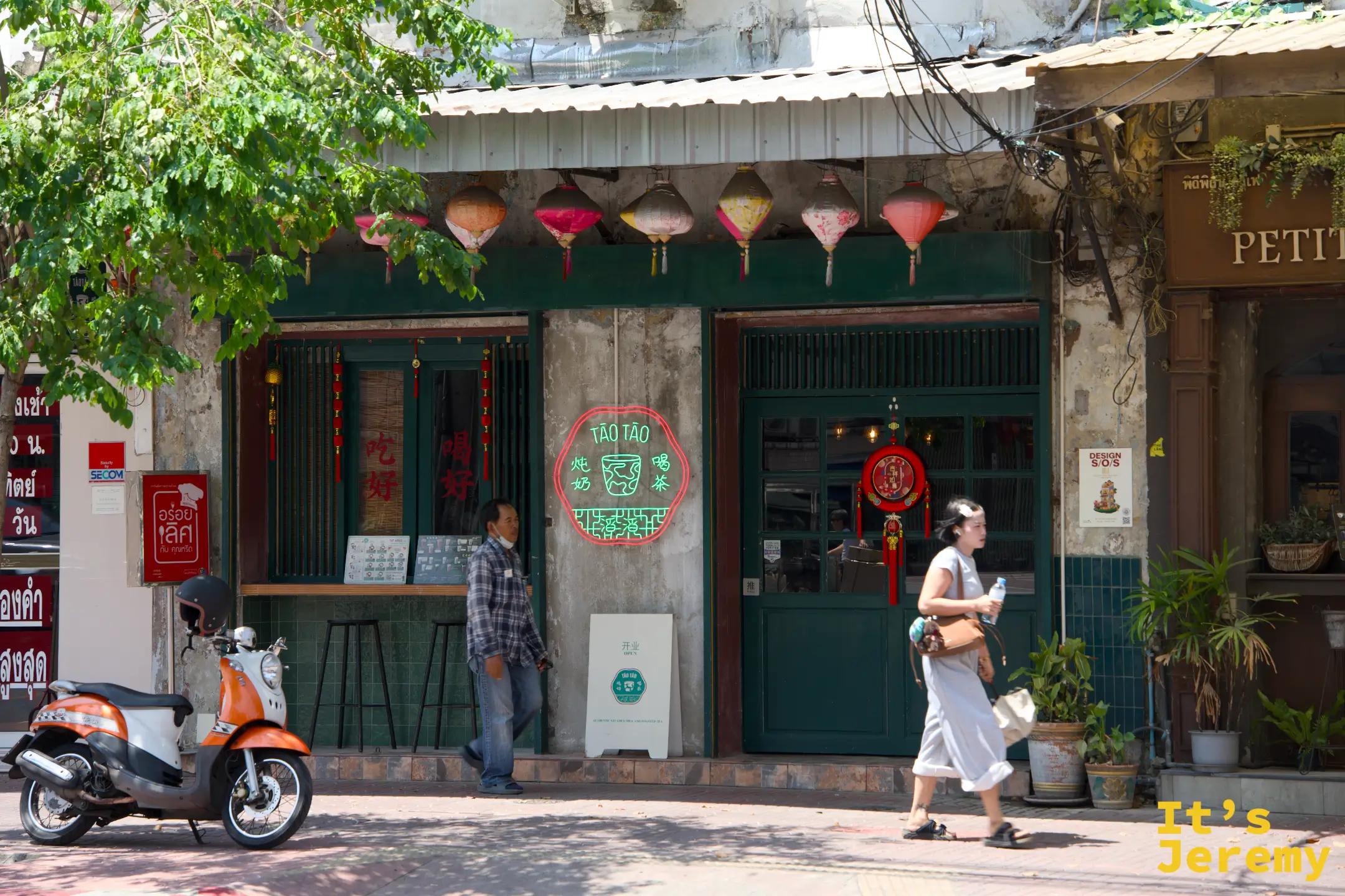 傍晚的 TaoTao 店門口，霓虹燈牌與木門框成的復古立面
