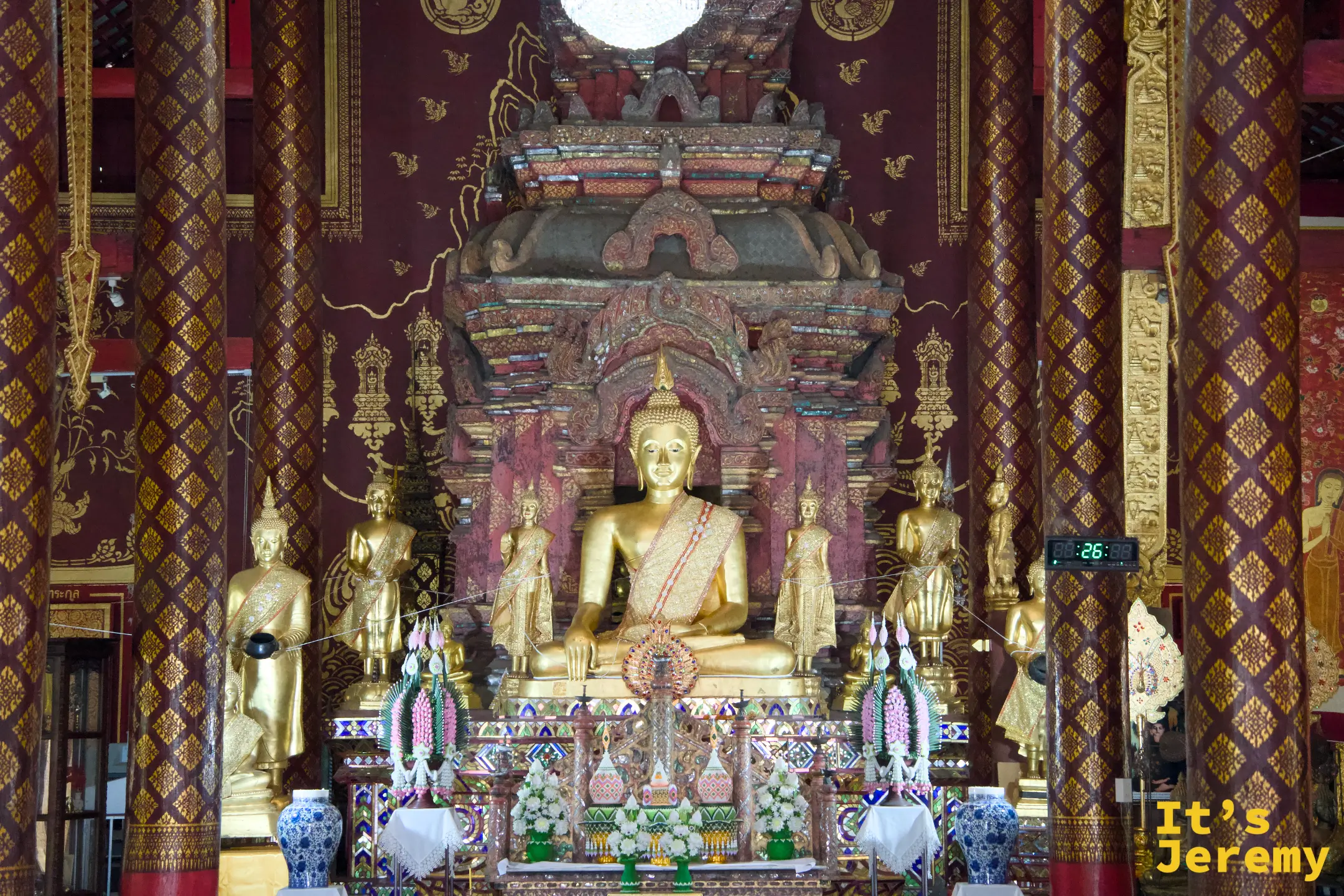主殿正面全景，金佛端坐高台，兩側侍立小佛像，後方背景壁畫宏大