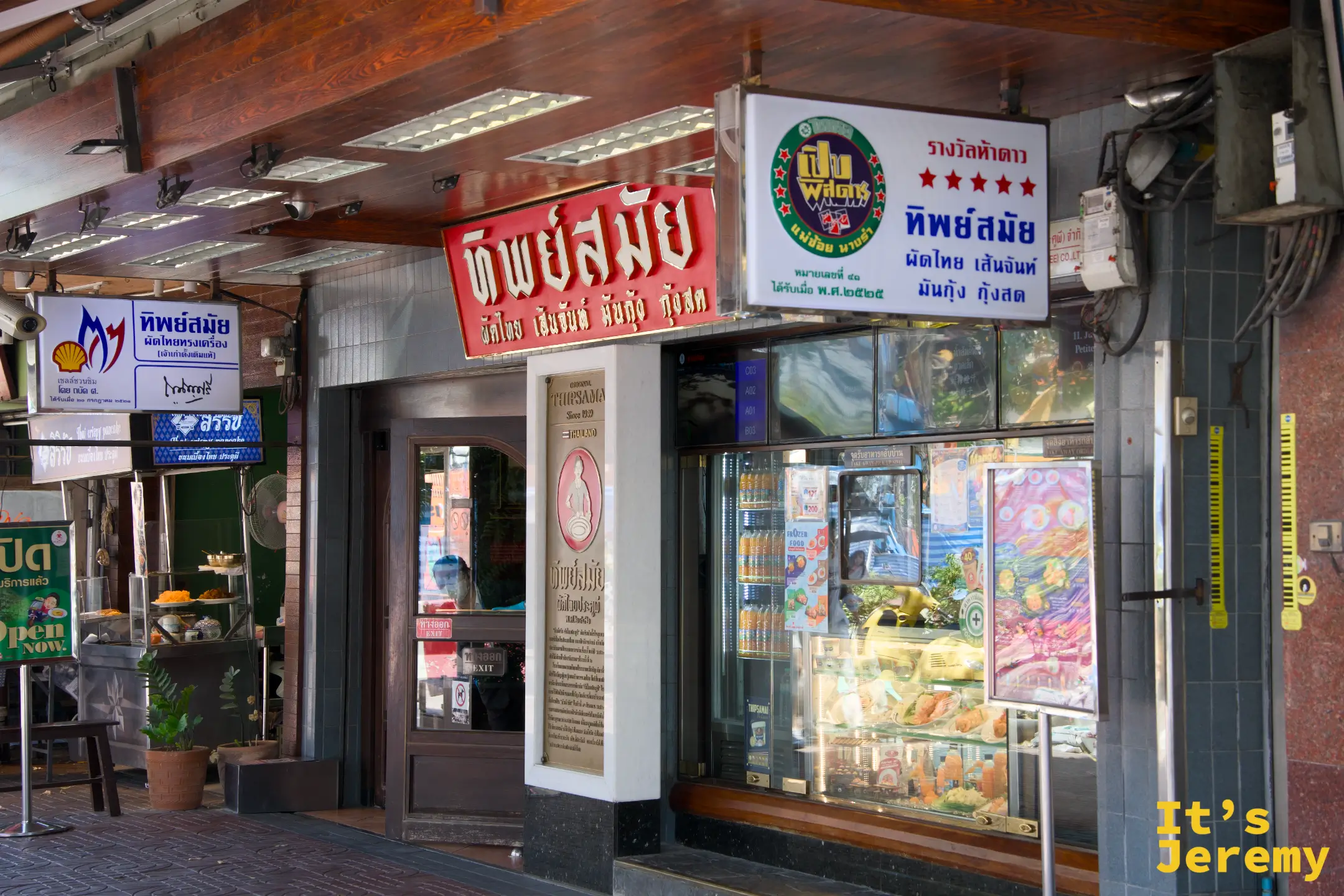 Thipsamai 店門口的橘色招牌與排隊人潮