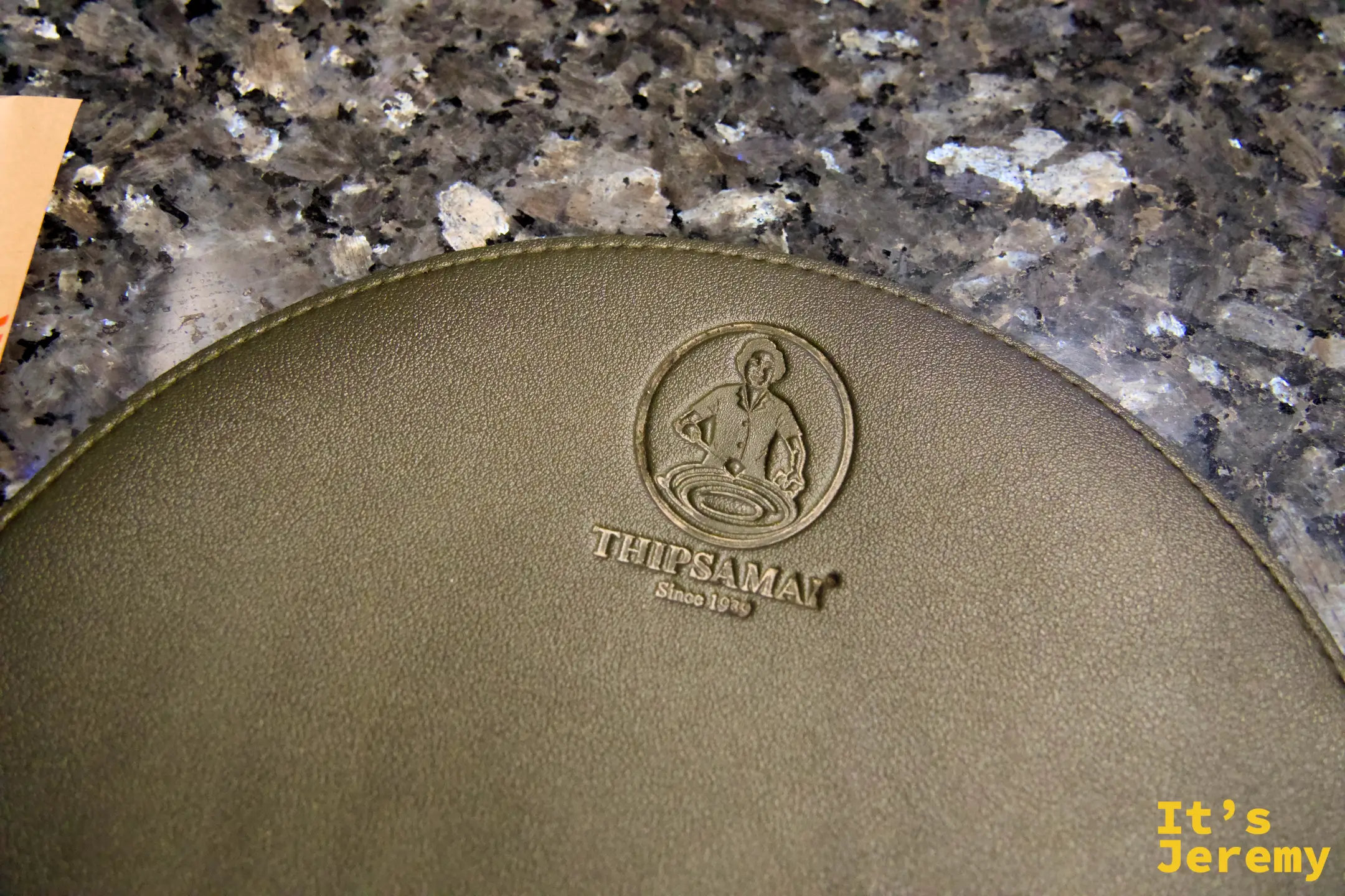Thipsamai 印著店家 logo 的襯盤紙墊細節