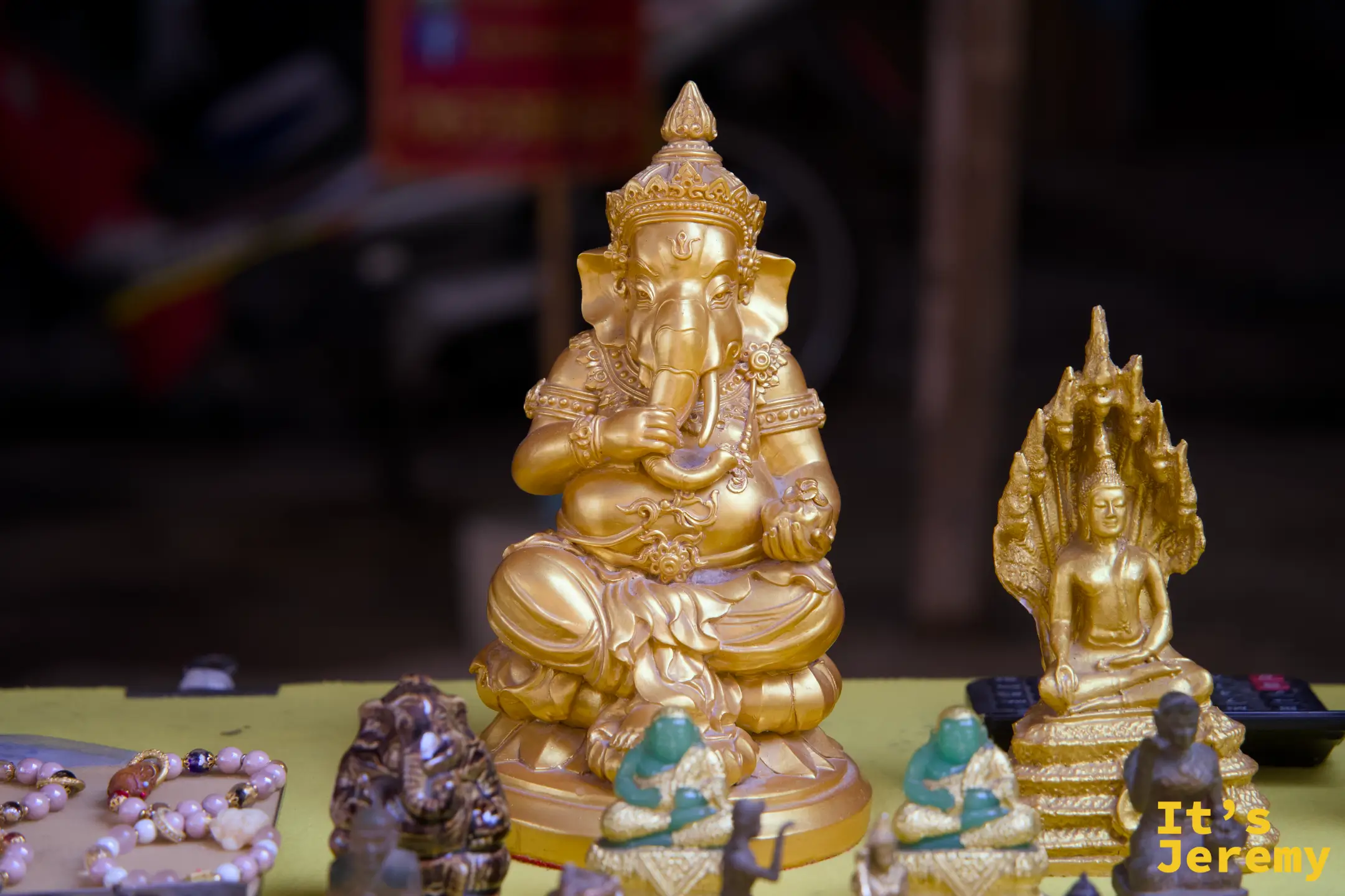 攤位上的象頭神（Ganesh）塑像與各式佛牌，陳列隨性，充滿市集氣息
