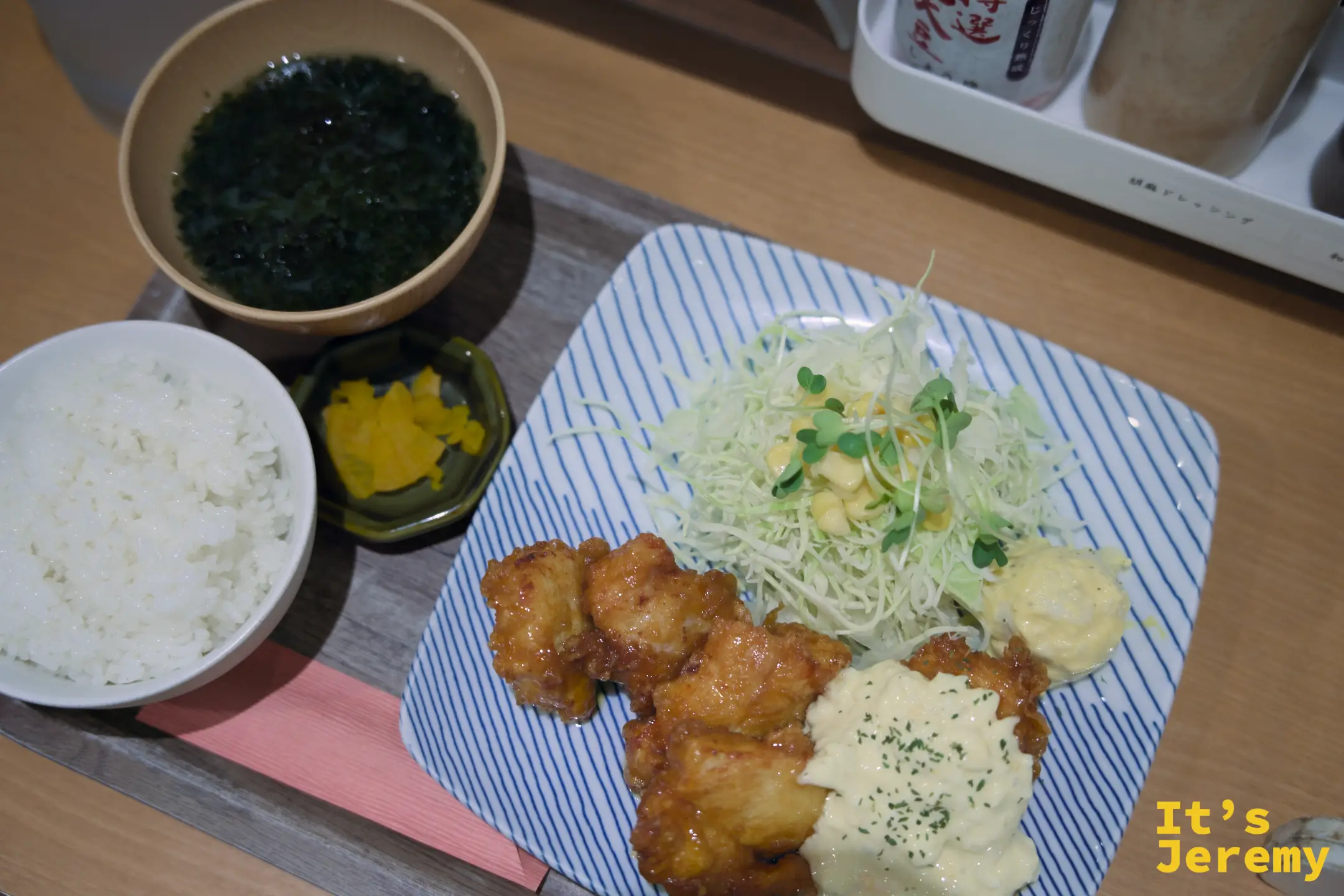 チキン南蛮定食套餐俯拍全景，藍白盤上的炸雞搭配沙拉、旁邊一碗白飯、醃漬物小碟和一碗深色海苔味噌湯