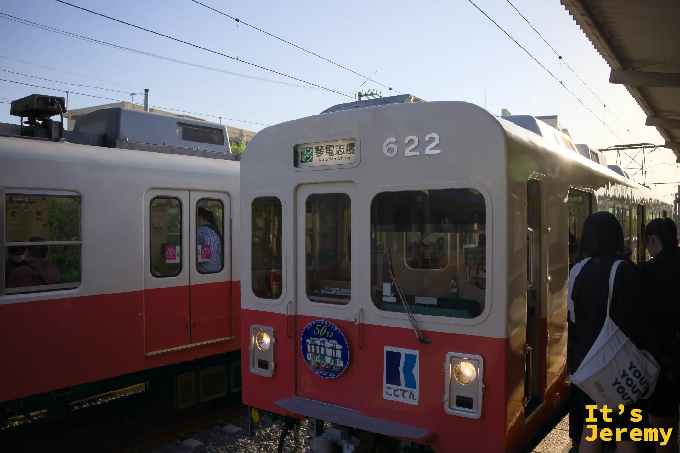 琴電622號電車往琴電志度方向，車身貼有50週年紀念徽章，夕陽從月台後方打進來