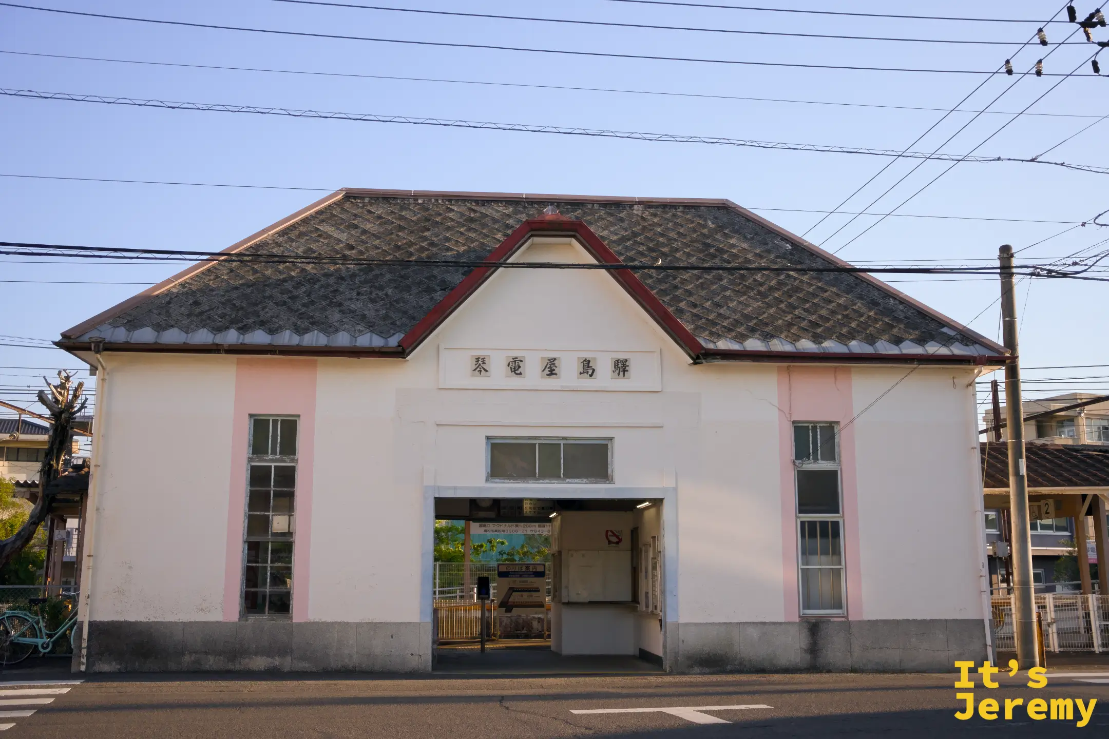 琴電屋島站站舍外觀，白牆灰瓦的復古建築，正面對稱，入口簡潔