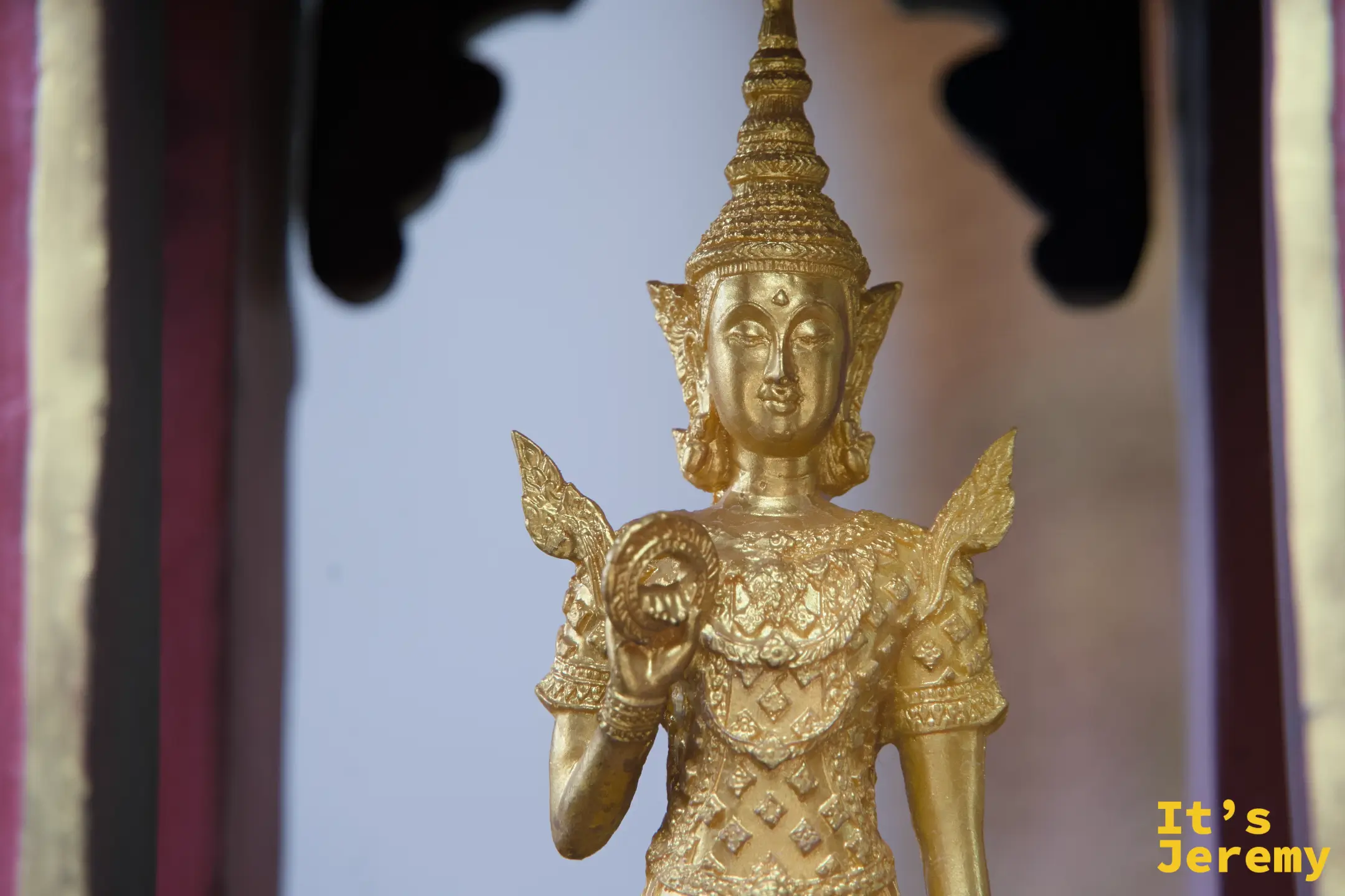 金色女性天神立像，雙手持法器，全身金色飾紋細密，神情優雅