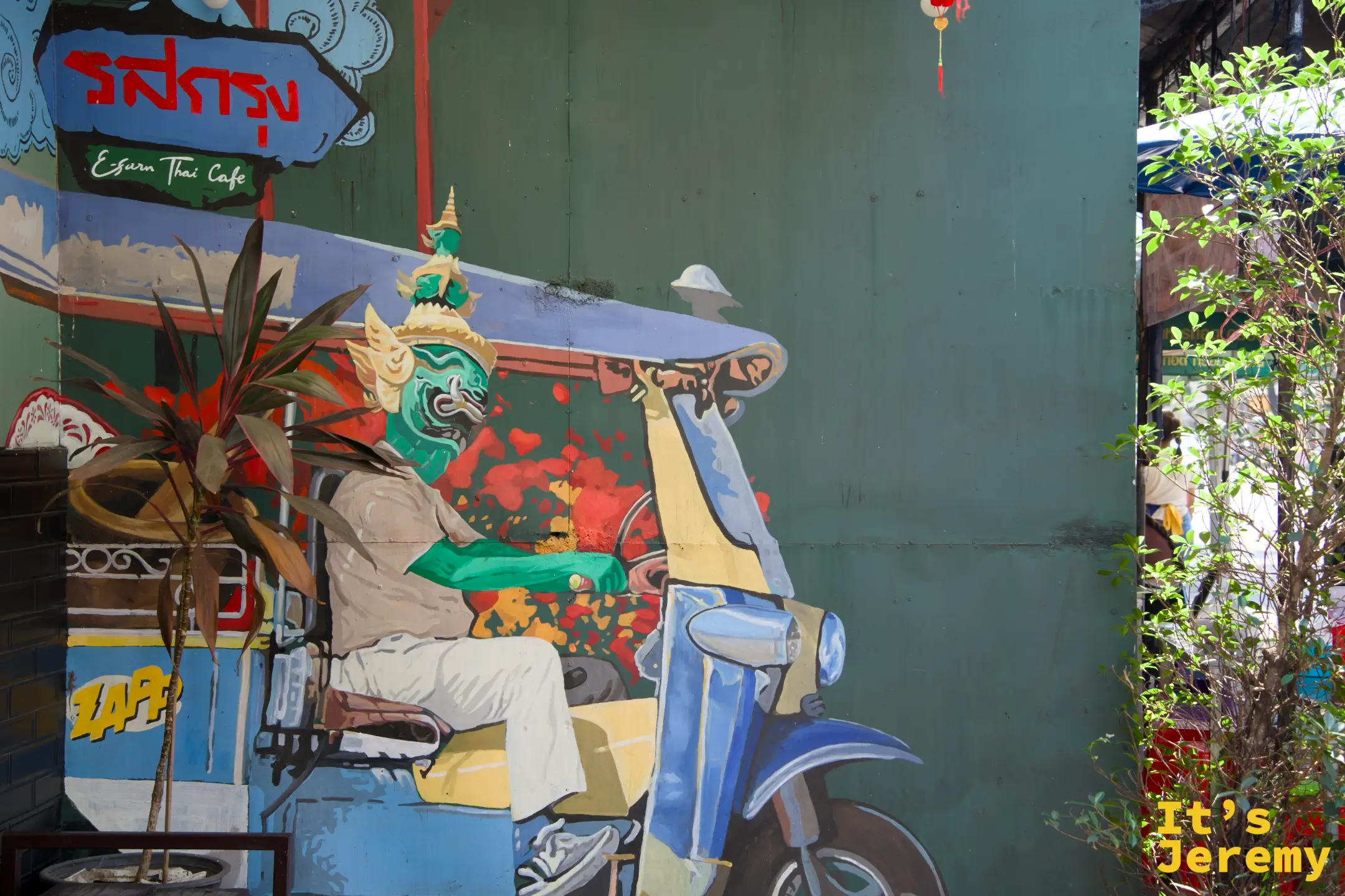 Edsuk Thai Café 綠色牆面塗鴉：戴泰拳面具的神話人物騎 tuk-tuk