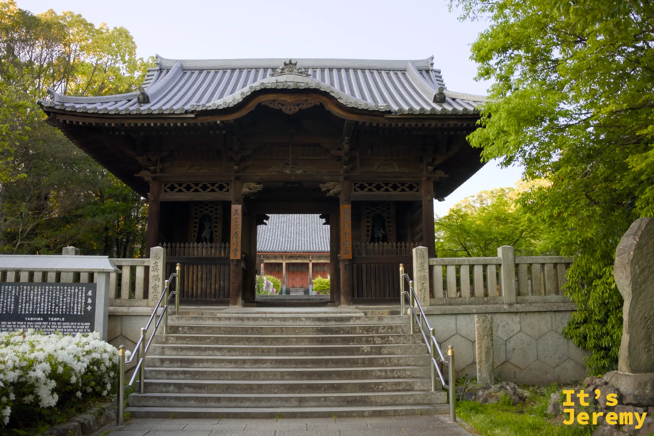 屋島寺山門近景，左右匾額清楚寫著「四國八十四番」「真言宗屋島寺」，後方紅色本堂居中