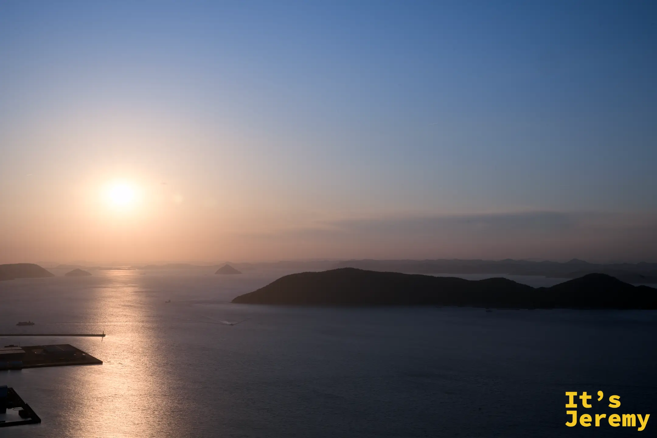 瀨戶內海日落，多座島嶼剪影由近至遠層疊，橙金色陽光在海面劃出長長倒影，天空漸層過渡