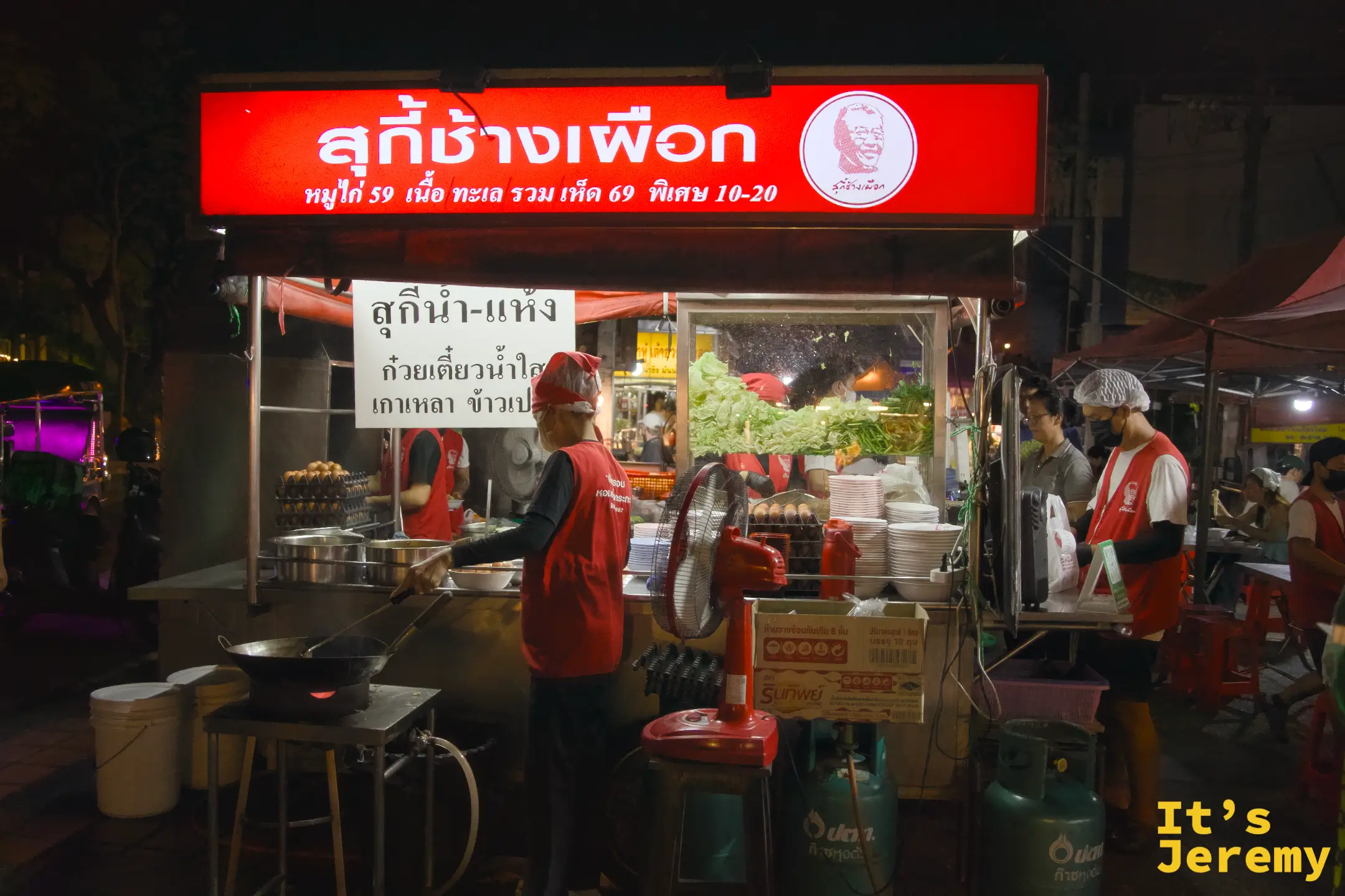 入夜後的สุกี้ช้างเผือก攤位，鮮紅招牌在黑夜中格外顯眼