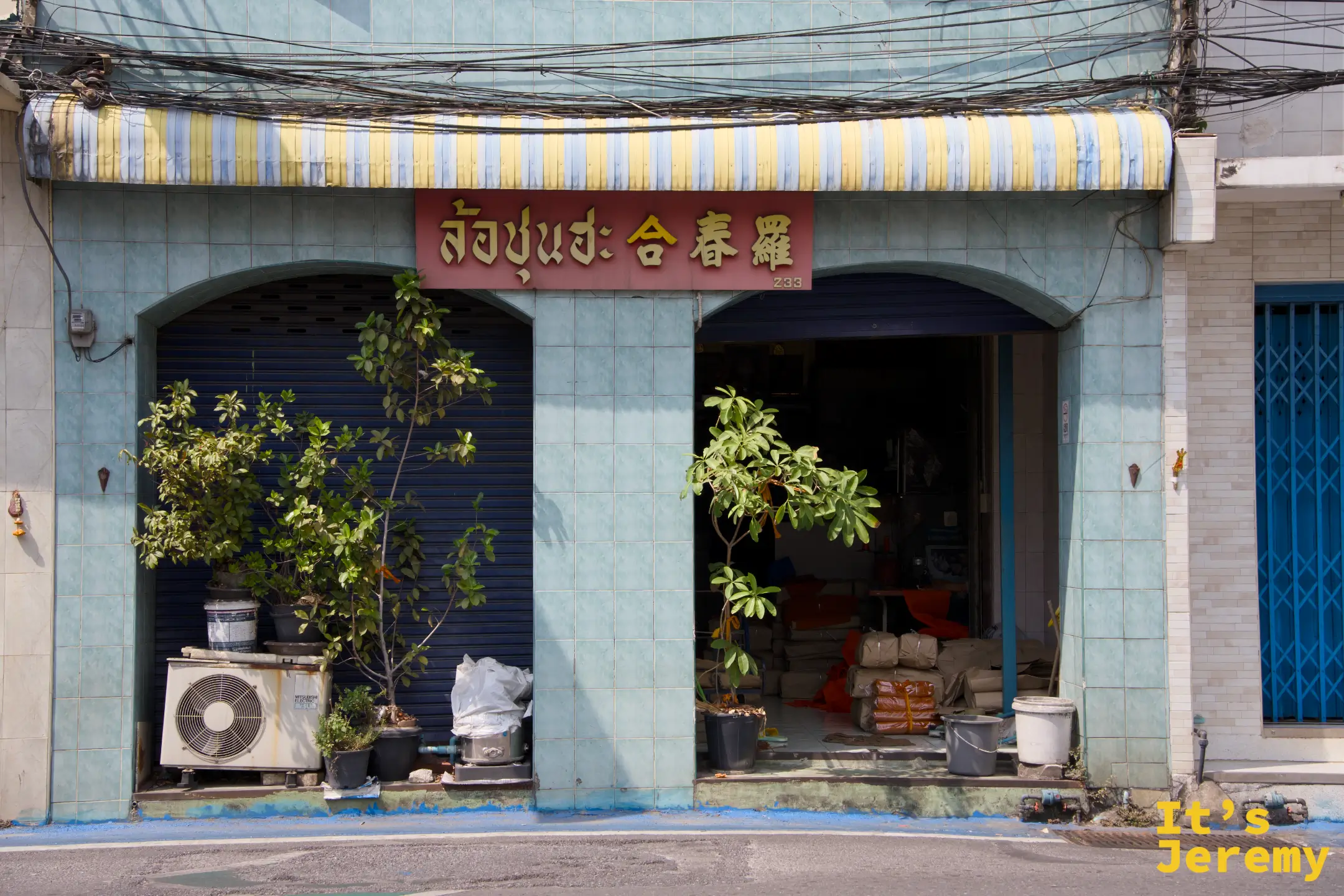 薄荷綠老店面與紅底金字的「合春羅」中泰雙語招牌