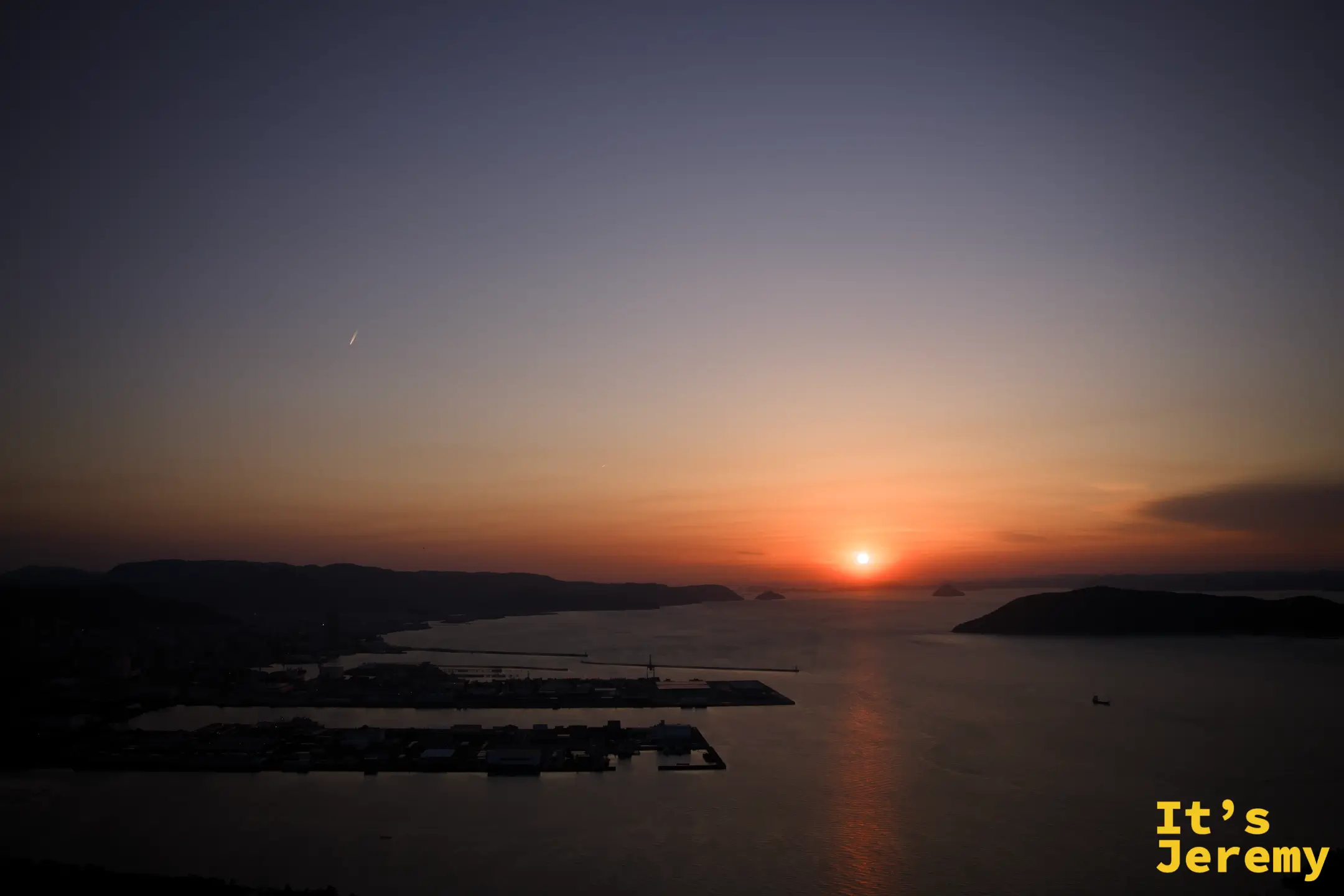 從屋島展望台俯瞰瀨戶內海與高松港，橙藍漸層的夕陽天色在海面展開