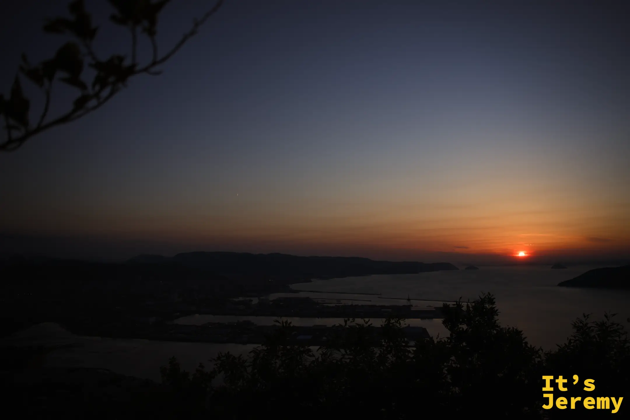 日落後橙藍漸層天空，高松港防波堤和碼頭剪影清晰，海面平靜，顏色還有最後的溫度