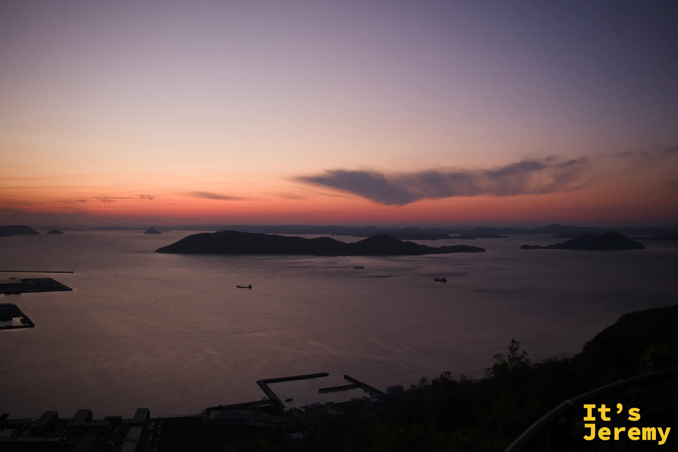 夜色加深，瀨戶內海多島景色在粉藍天空下呈現，薄雲飄過，海面如鏡