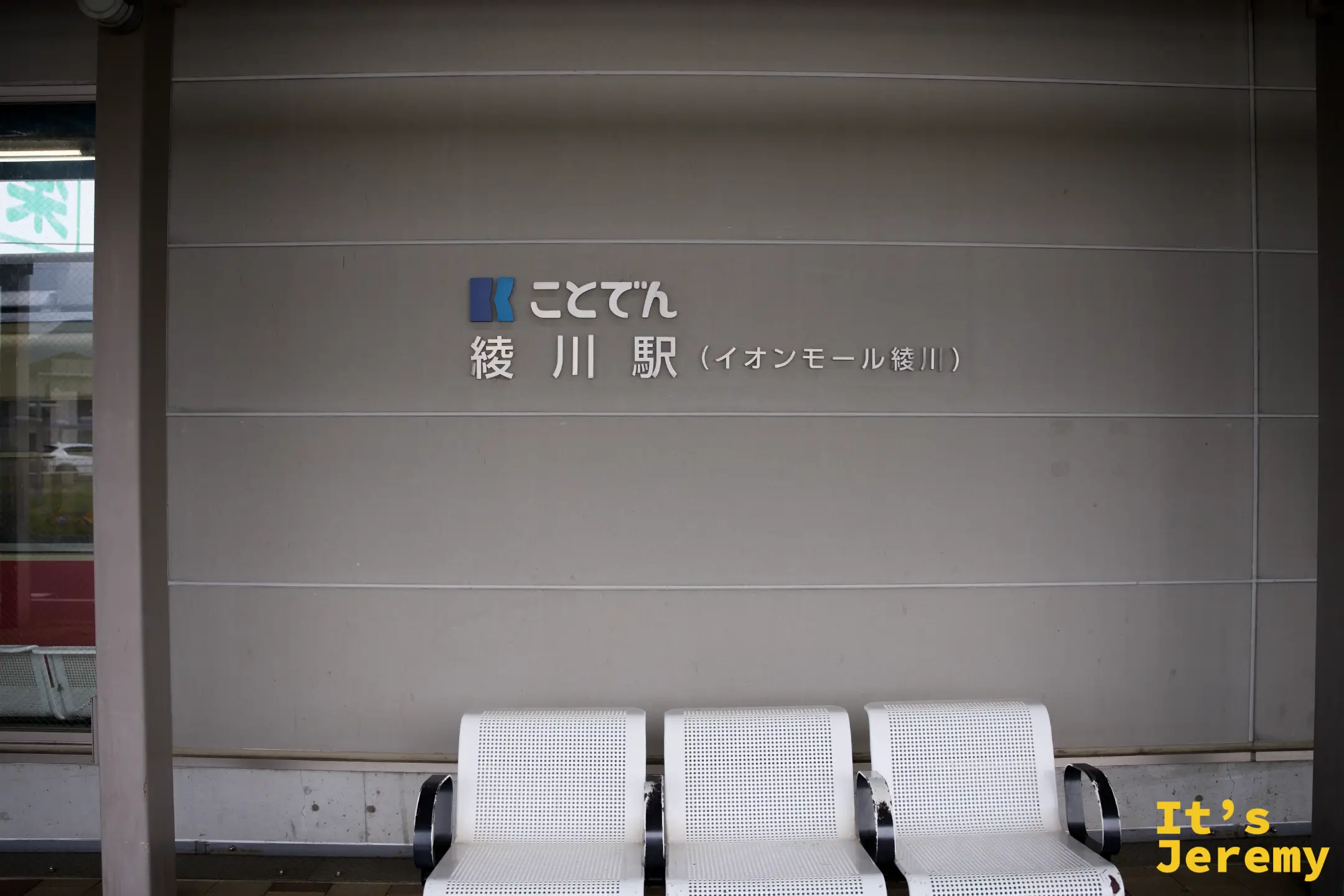 琴電綾川駅的月台候車區，白色長椅前牆面掛著「ことでん 綾川駅（イオンモール綾川）」站名牌